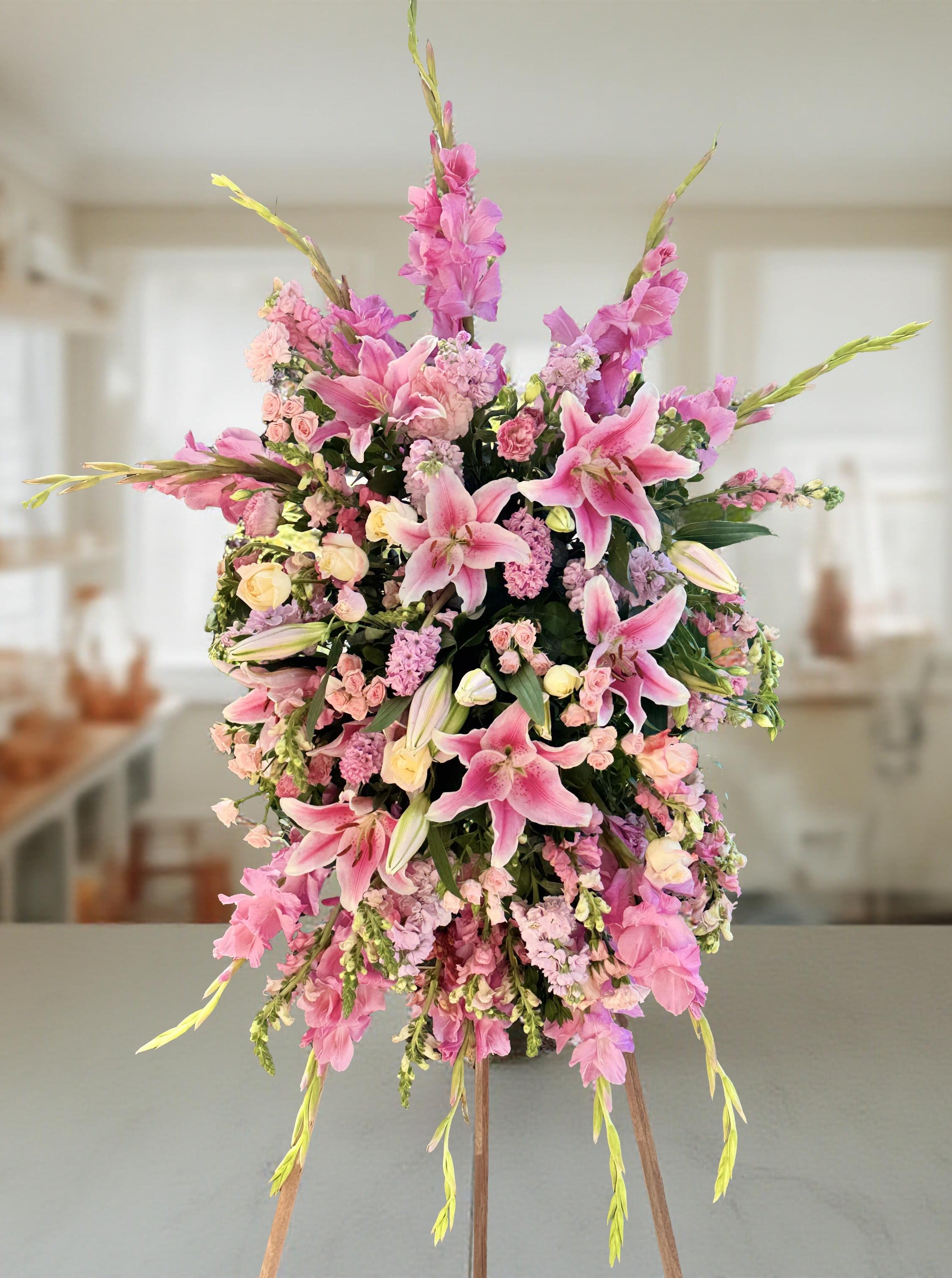 Tall pink floral arrangement with lilies and spray flowers