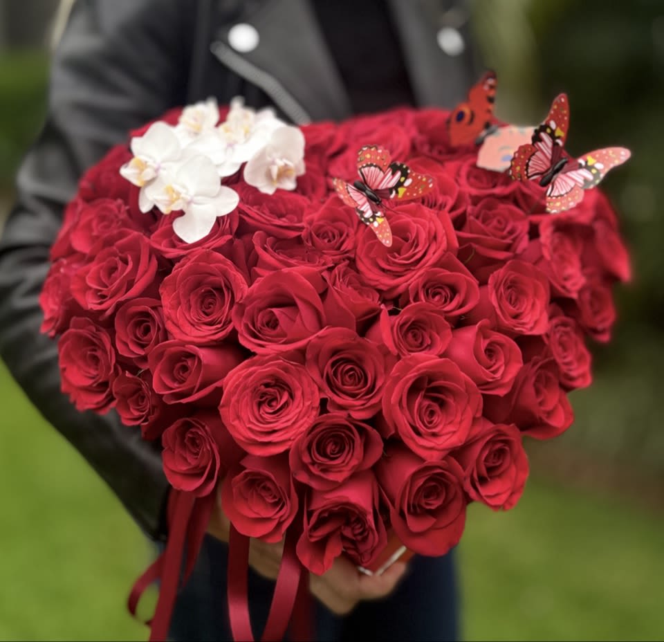 Heart-shaped bouquet of red roses with white orchids and butterfly picks