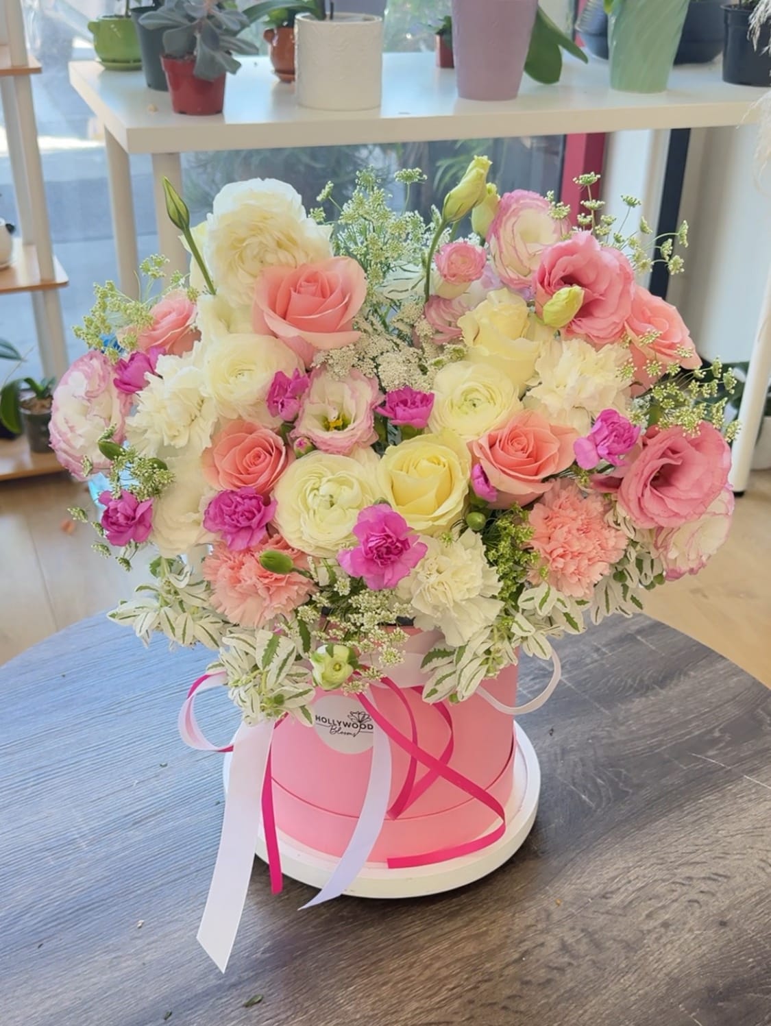 Pink and cream rose bouquet in a round pink box with ribbons