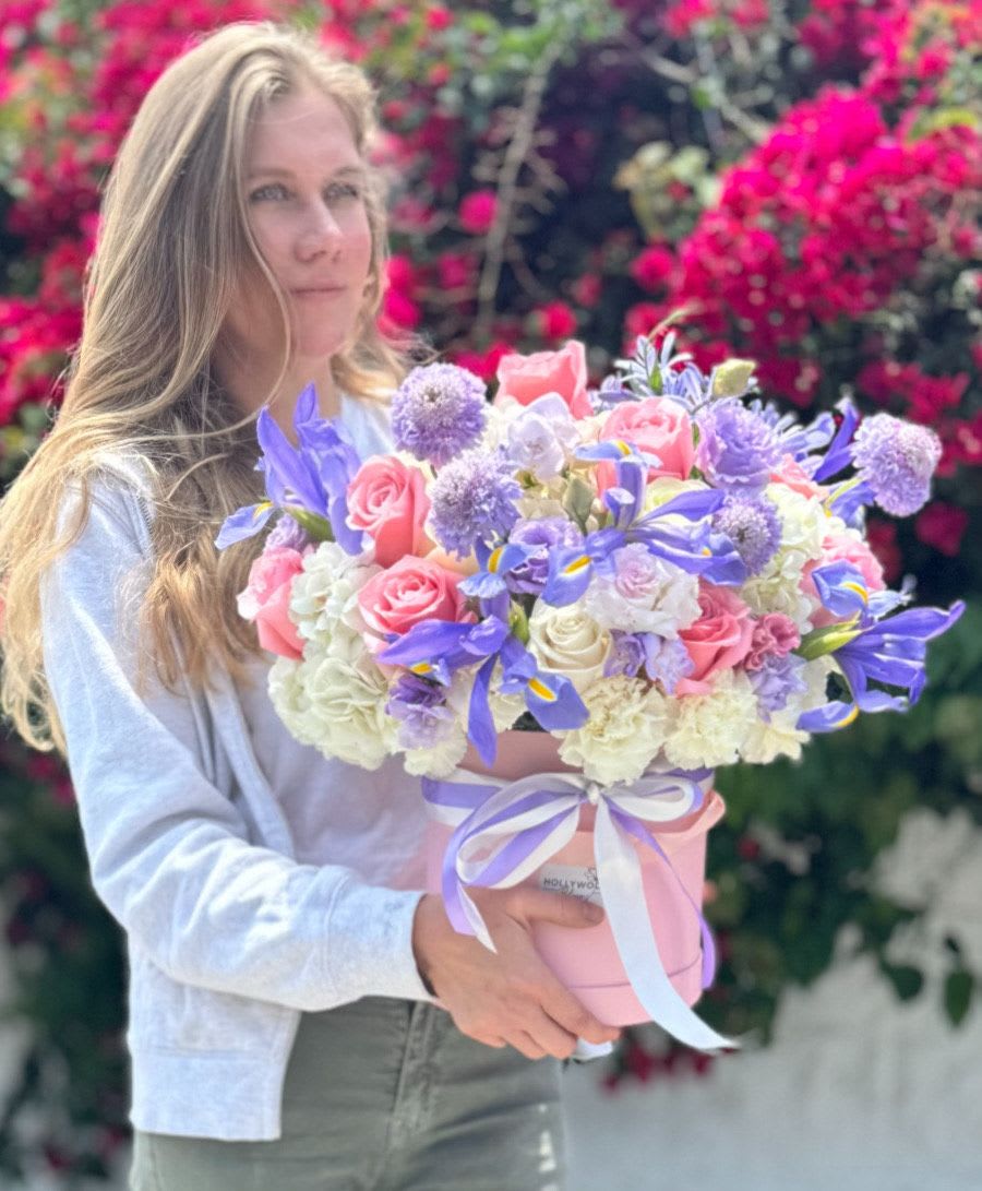Woman holding a pastel bouquet in a pink hatbox
