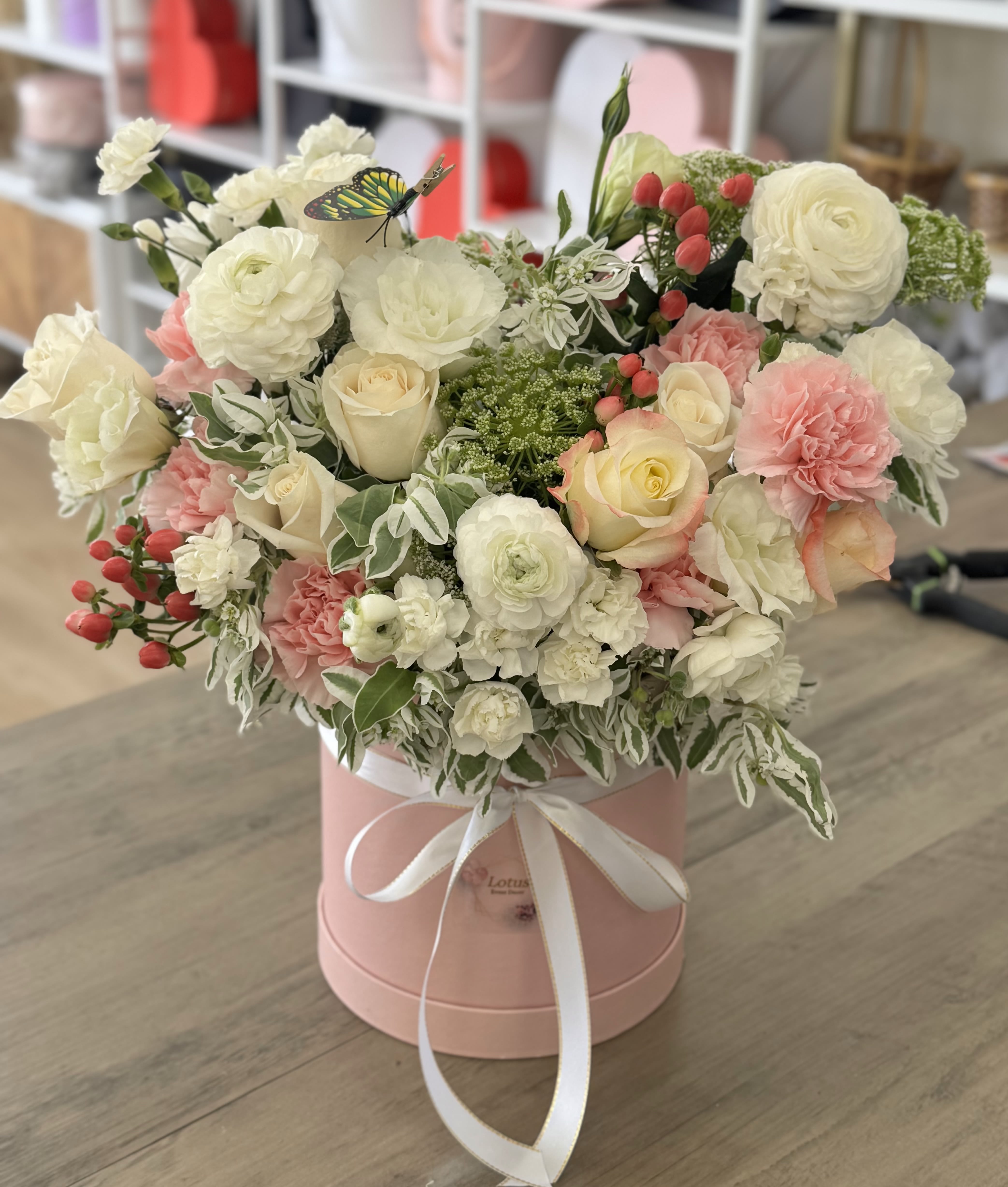Pink hatbox arrangement with white and blush roses and carnations