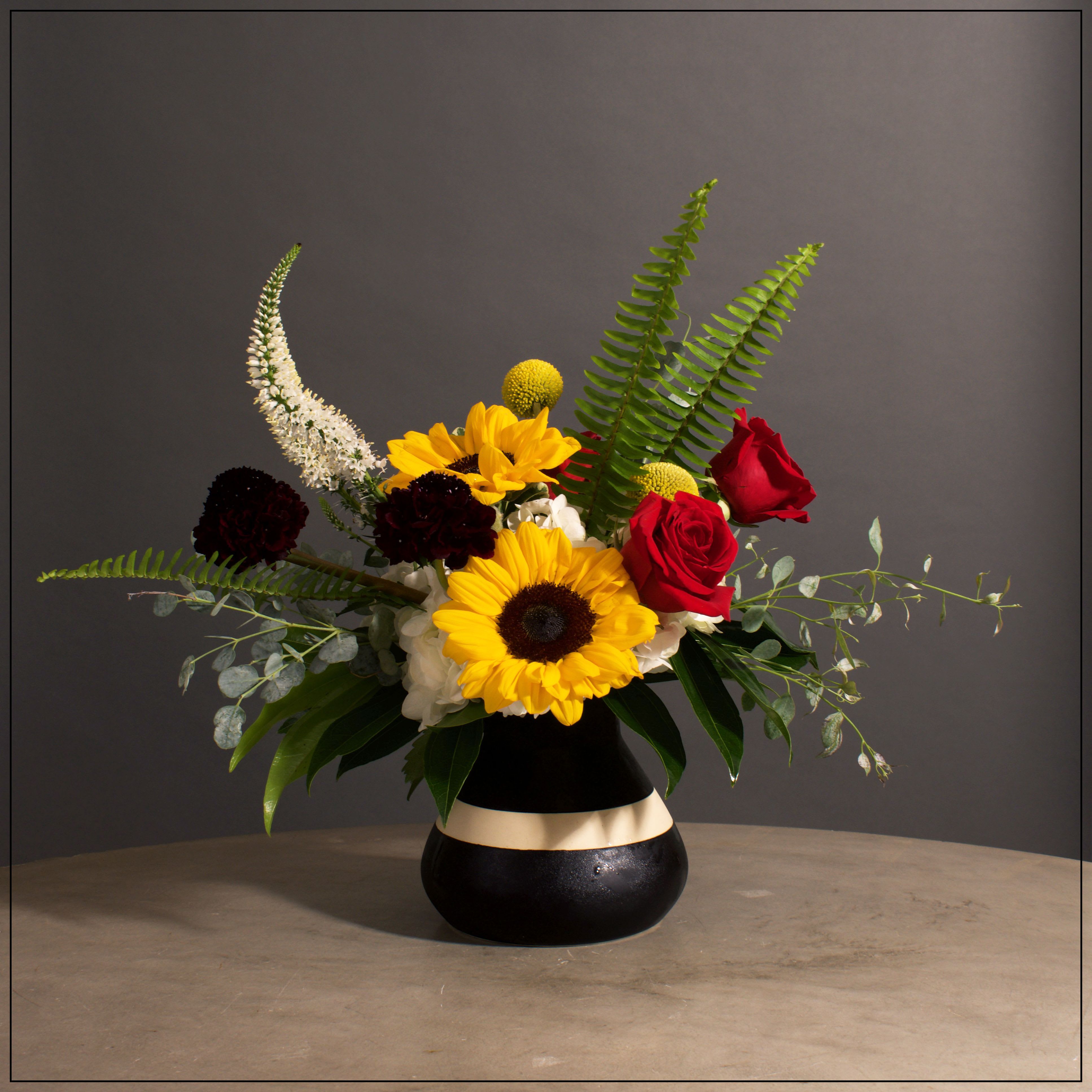 Big Top - Black and white ceramic vase filled with hydrangea, scabiosa, roses, sunflowers, Billy balls, and veronica. Approximately 13" tall adn 13" wide.