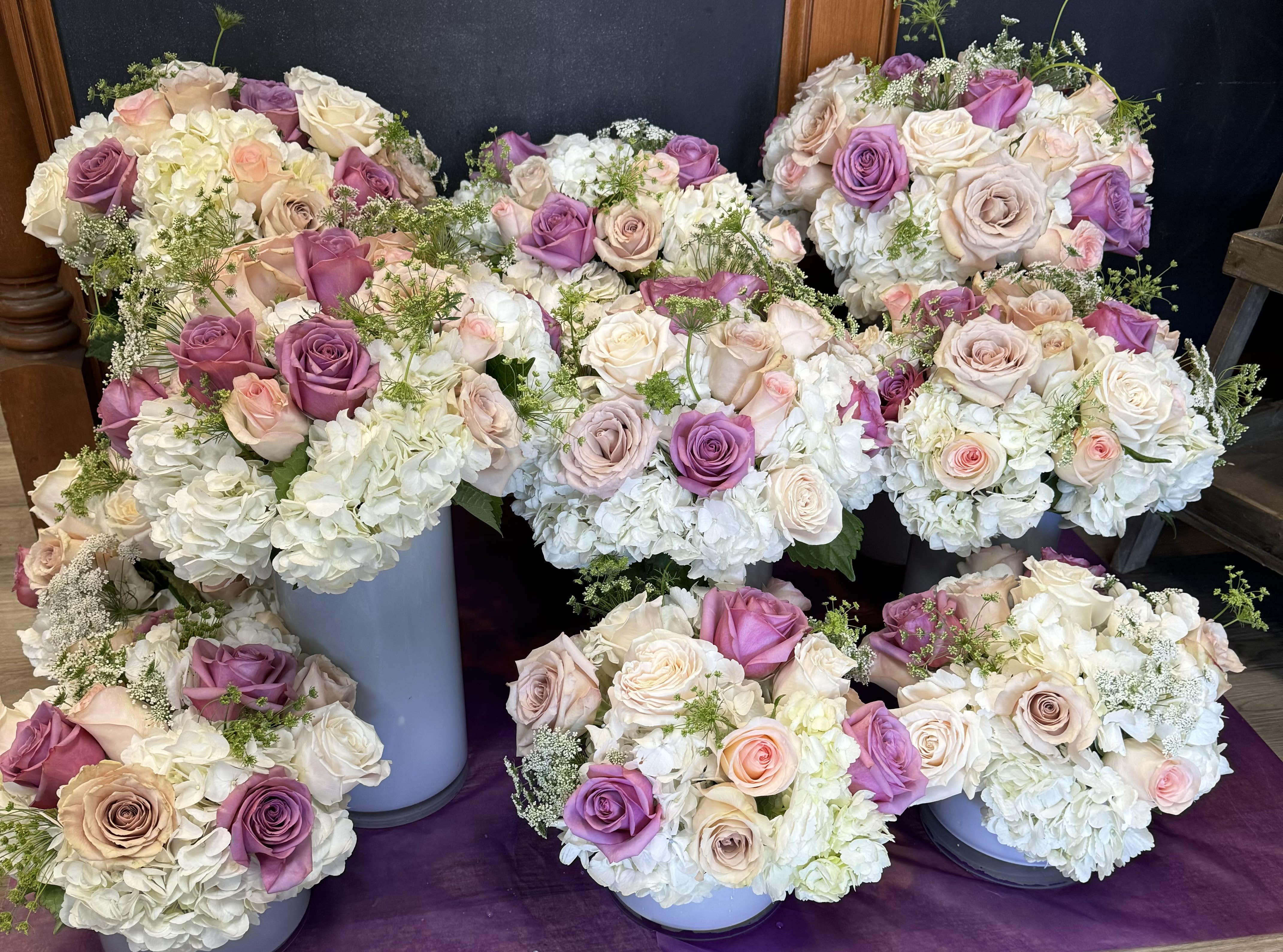 Clusters of pastel roses and white hydrangeas arranged in round bouquets