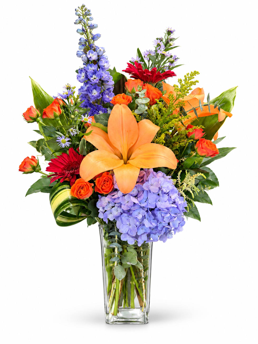 Colorful bouquet with lilies, roses, hydrangeas, and a clear glass vase