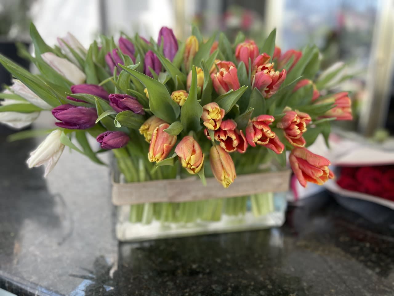 Bouquet of multicolored tulips in a clear glass vase