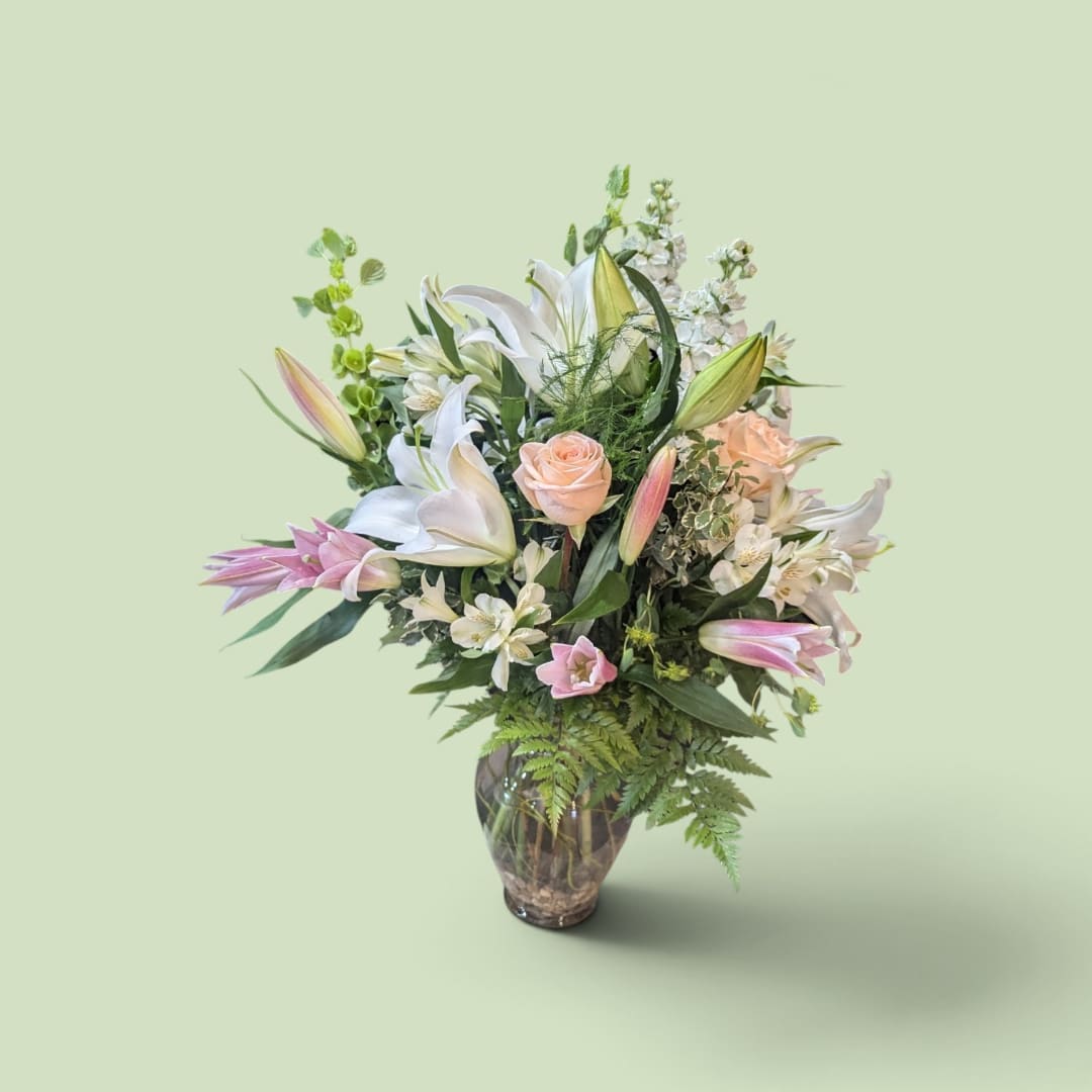 Mixed bouquet of lilies and roses in a glass vase