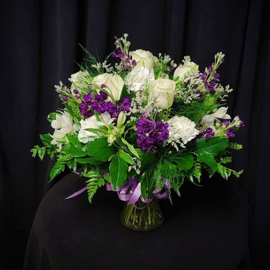 White and purple mixed bouquet in a glass vase