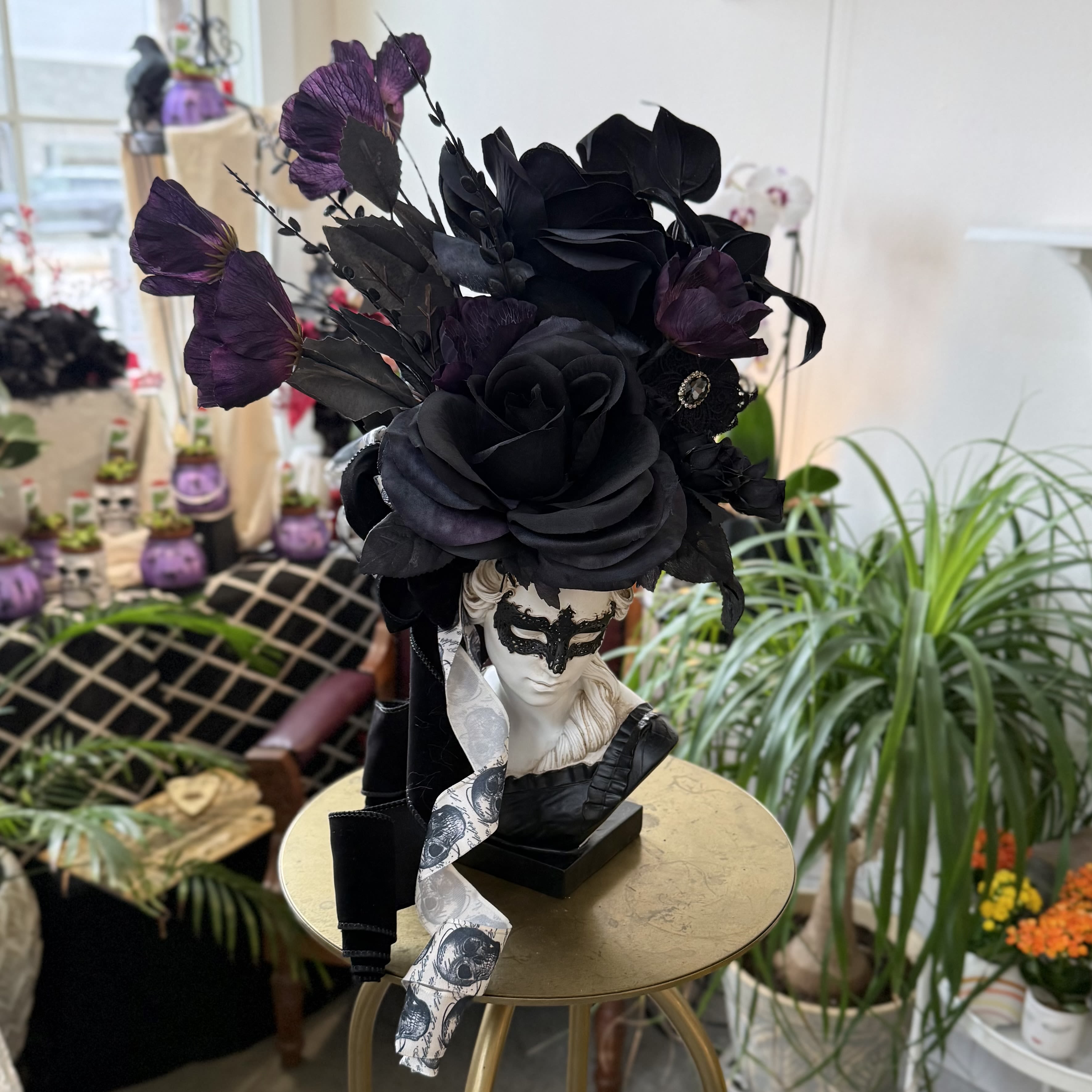 Black floral headpiece on a mannequin bust with purple accents