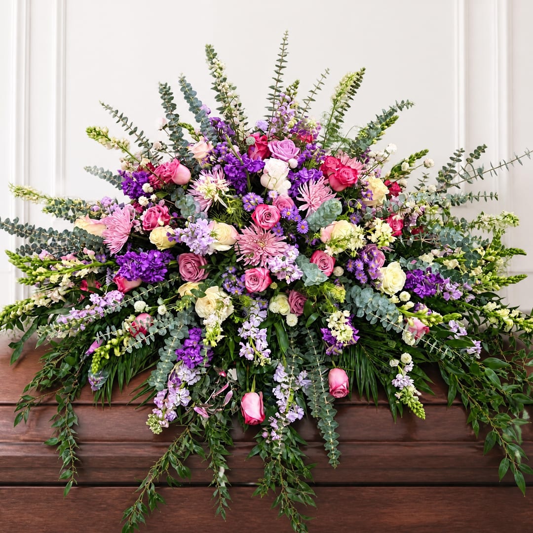 Large mixed bouquet of pink, purple, and white flowers with trailing greenery
