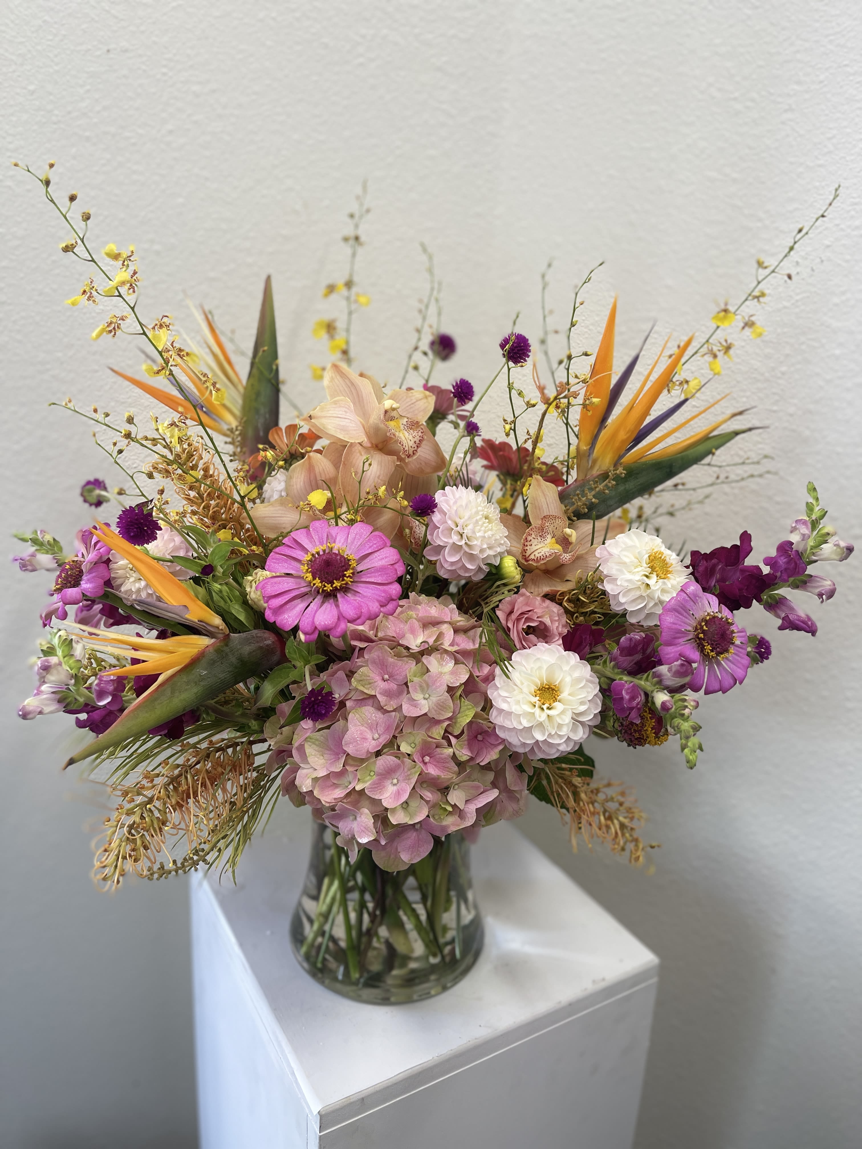 Mixed bouquet in a clear glass vase with pink, white, purple, and orange blooms