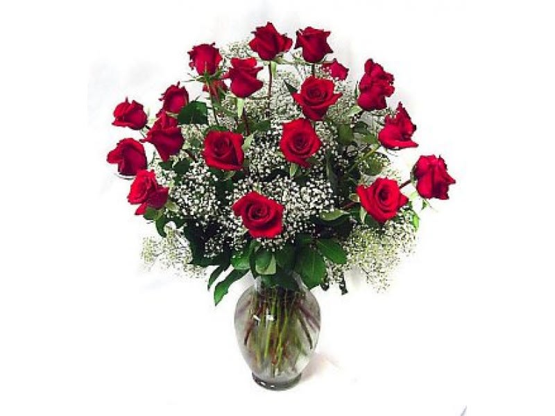 Red roses arranged in a glass vase with baby's breath