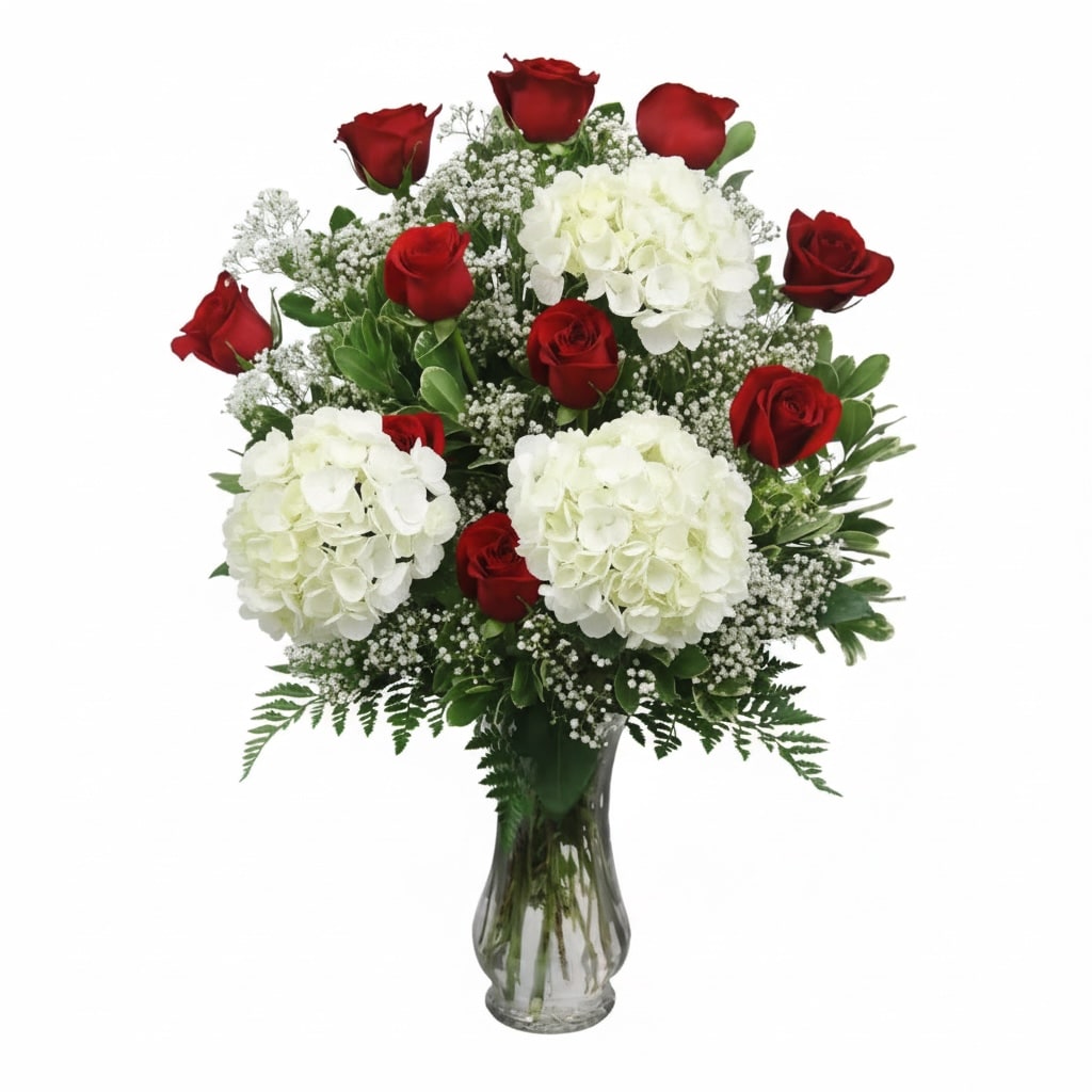 Red roses and white hydrangeas in a clear glass vase