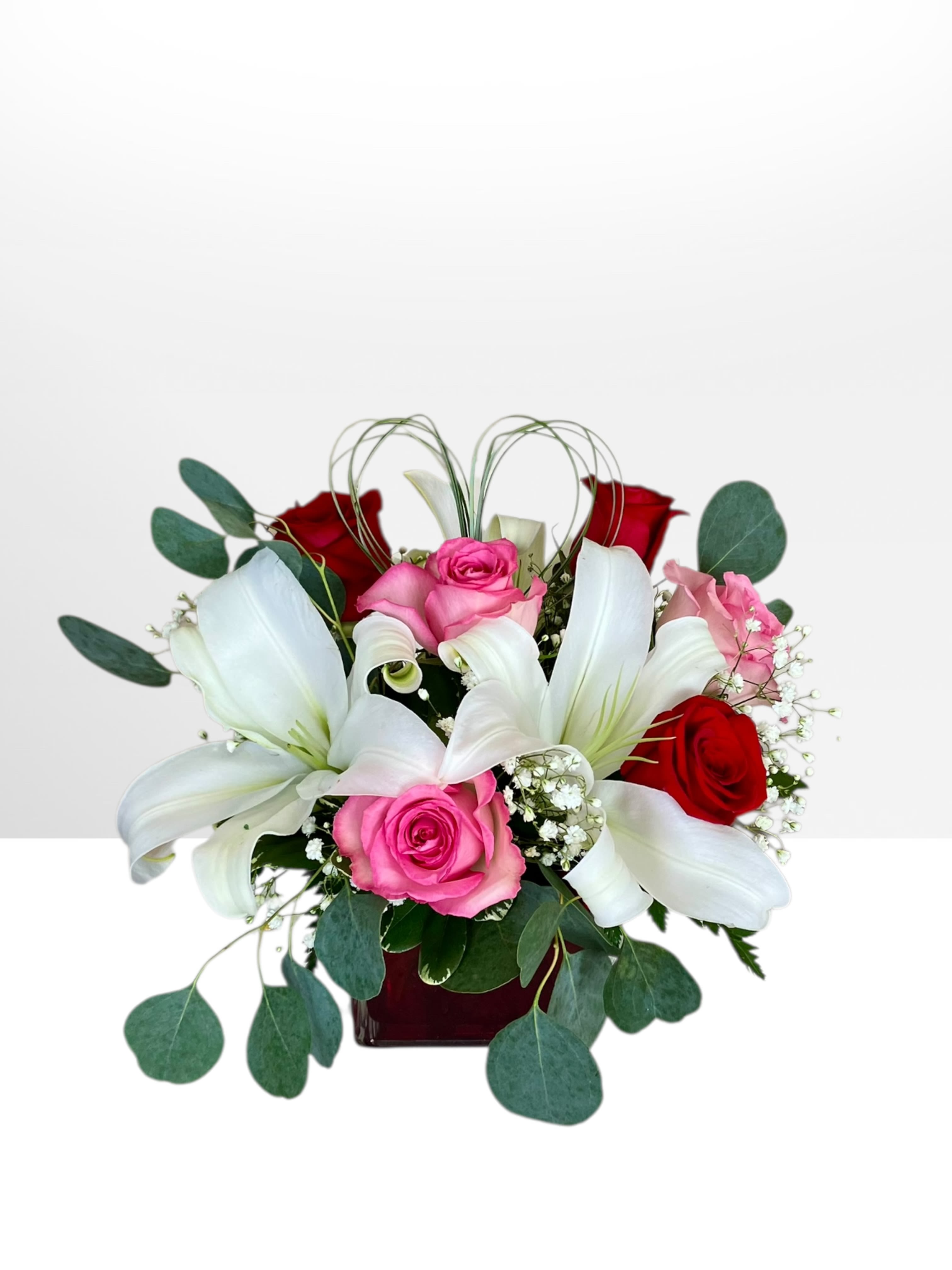 Bouquet of red and pink roses with white lilies in a vase