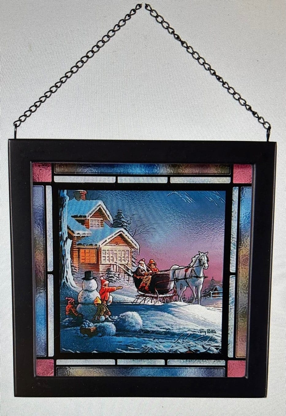 Framed winter scene with a chain hanger and a sleigh beside a snowman