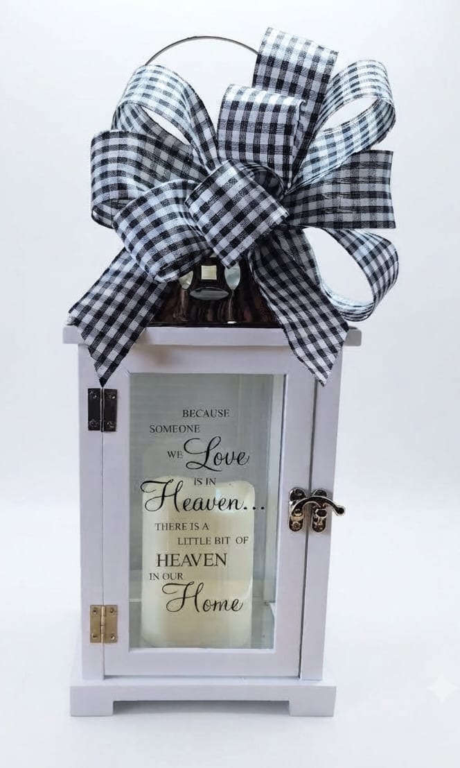 Decorative white lantern with a black-and-white bow and memorial quote