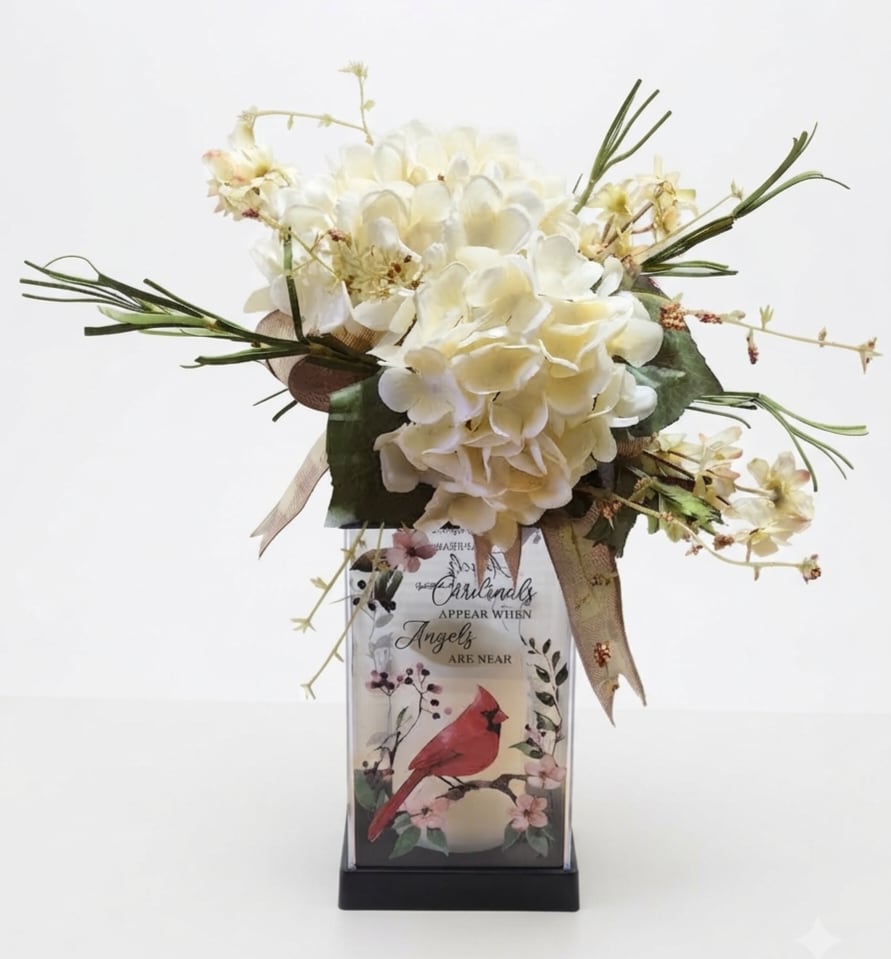 Cream floral arrangement in a decorative vase with a bird design