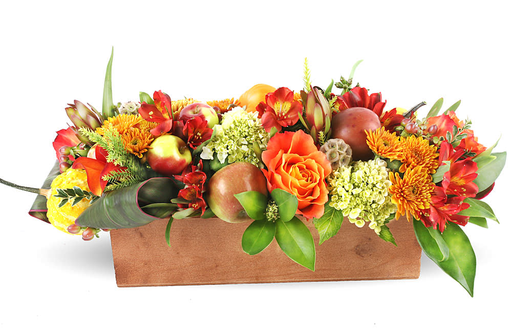 Autumn floral arrangement in a rectangular wooden box with orange and red blooms