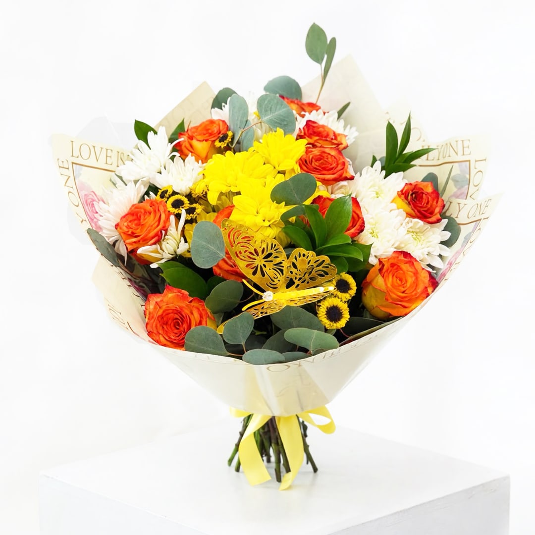 Bouquet of orange roses, yellow blooms, and white daisies wrapped in paper