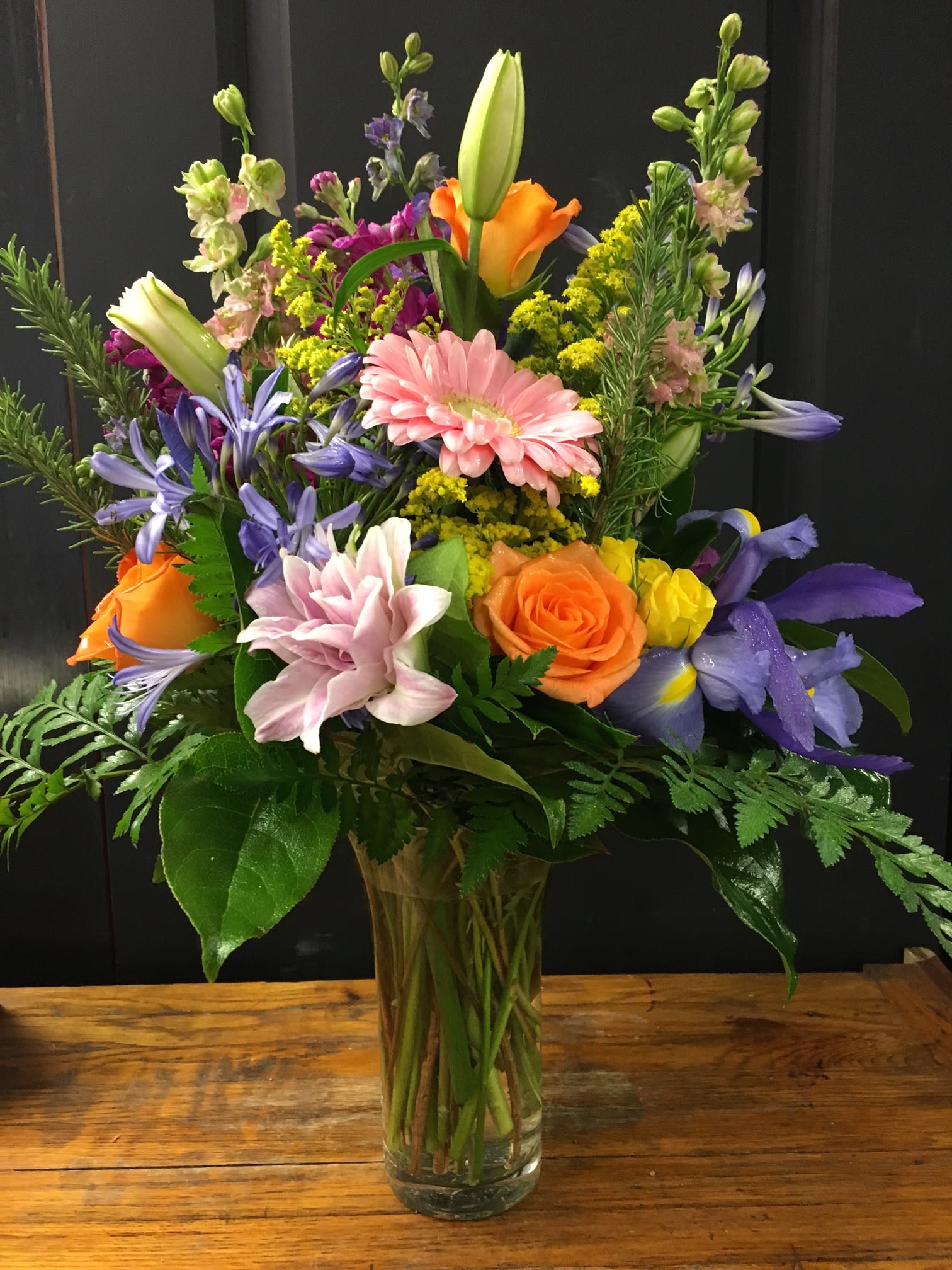 Mixed bouquet of colorful flowers in a clear glass vase