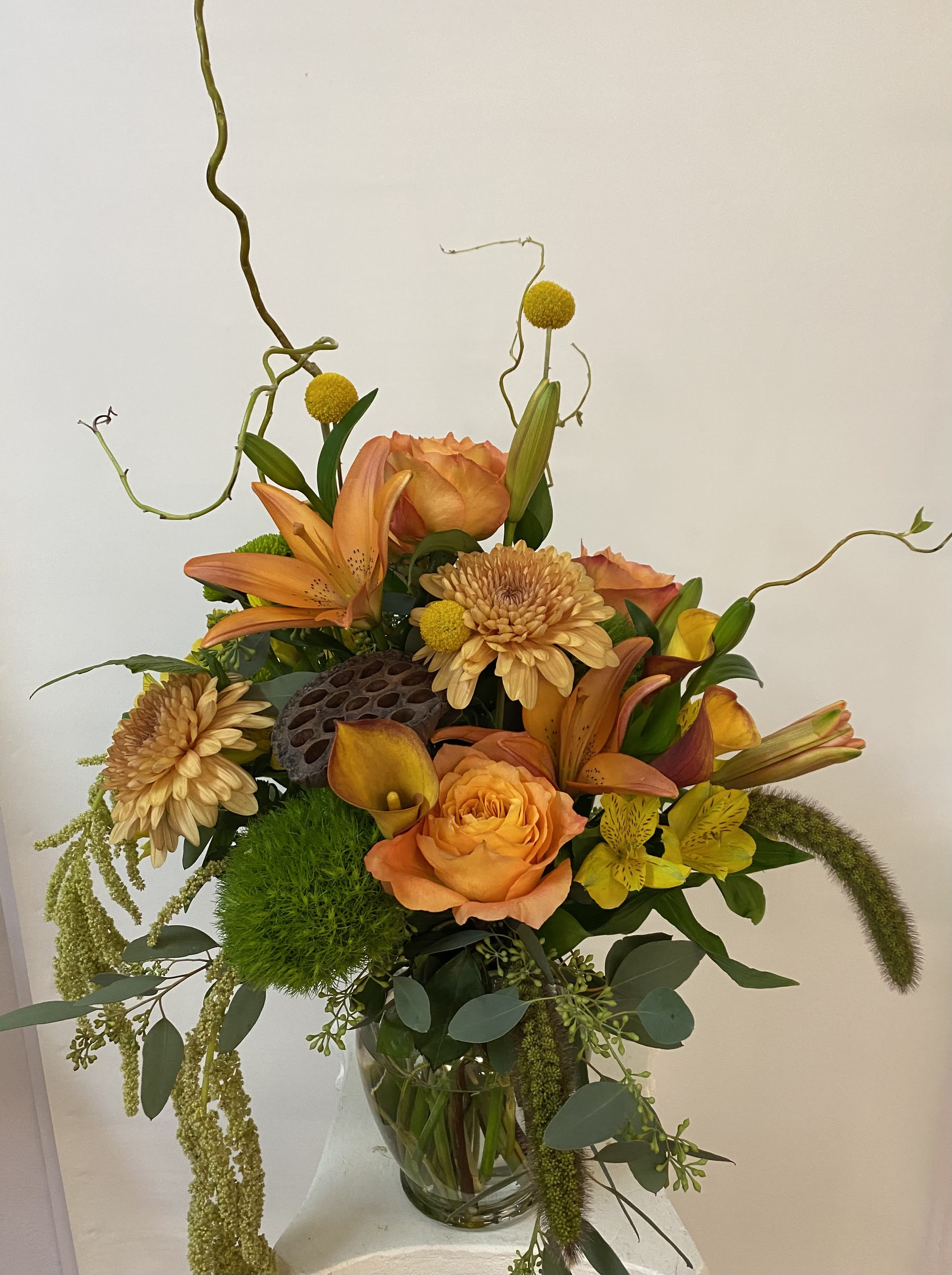 Orange and yellow floral arrangement in a clear glass vase