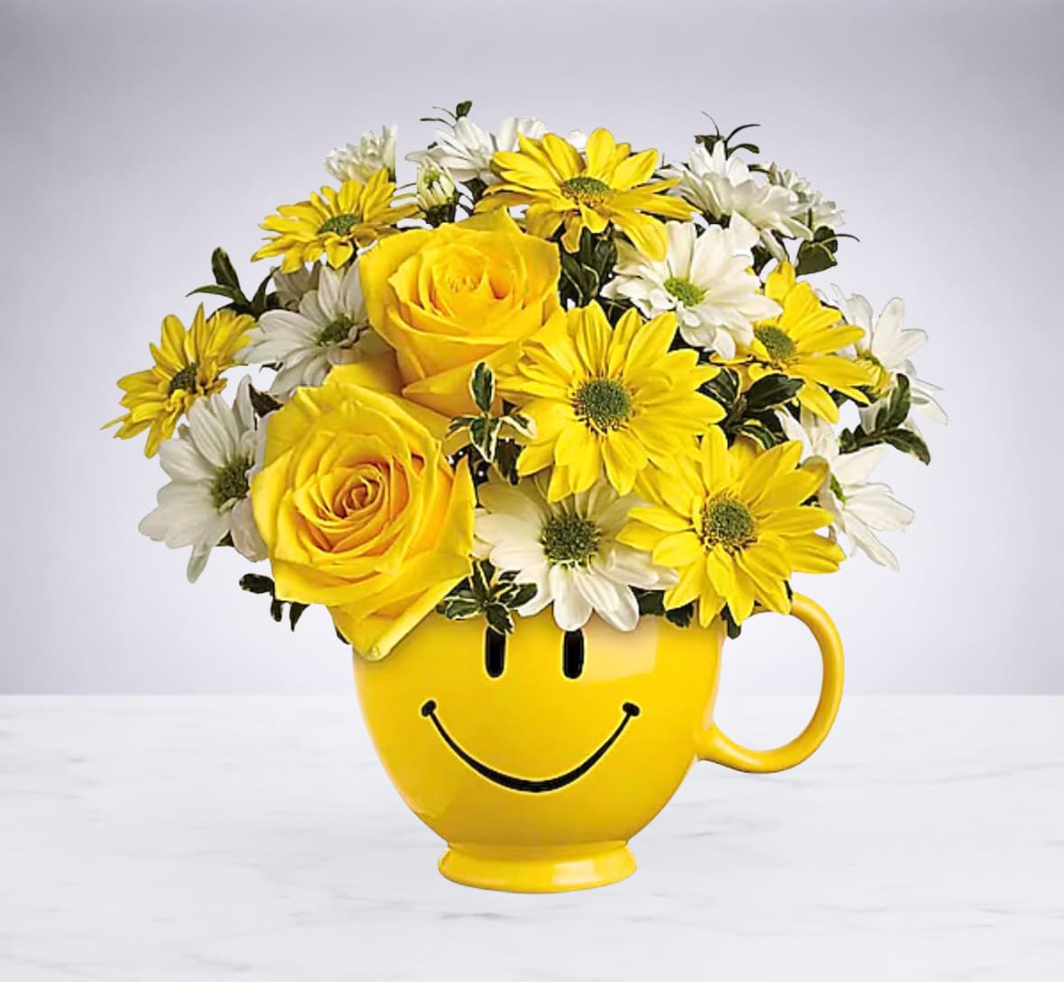 Smiley Face Mug - Bring instant smiles with this bright and happy arrangement, designed in a sunny yellow smiley mug that adds charm long after the flowers are enjoyed. A fun and uplifting gift that delivers happiness at first sight. 