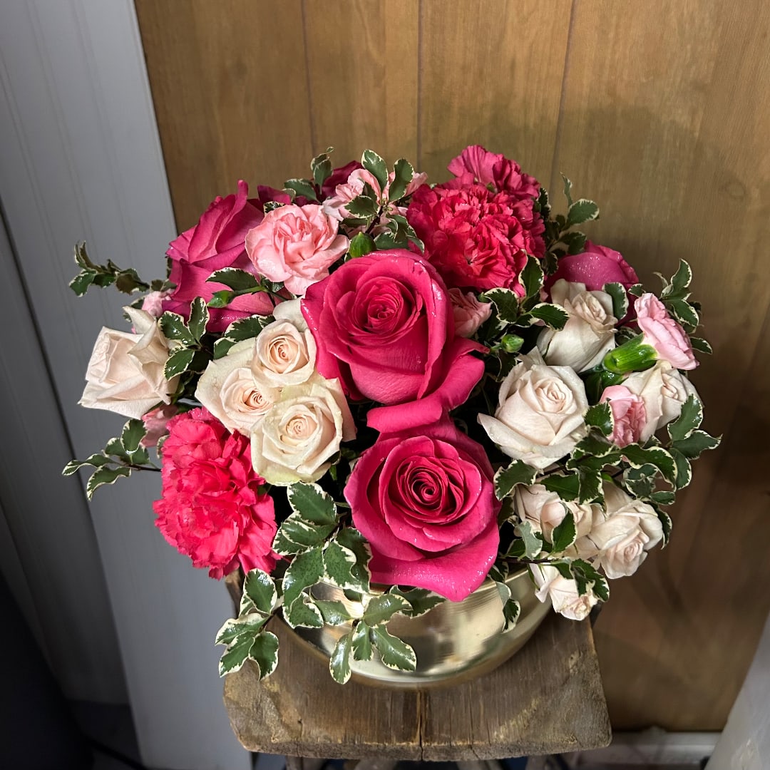 Pink and cream roses with carnations in a gold vase