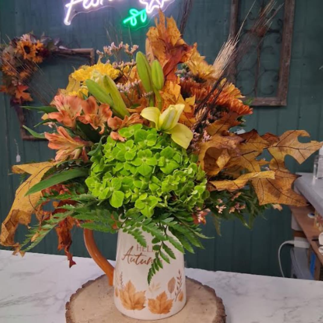 Autumn bouquet in a white pitcher vase with green hydrangea and lilies