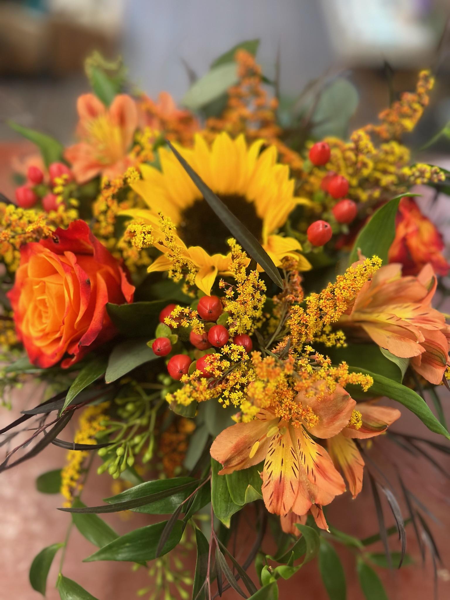 Orange and yellow mixed bouquet with a sunflower and roses