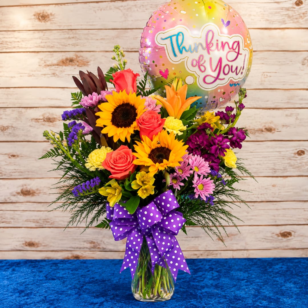 Mixed bouquet in a glass vase with a Thinking of You balloon