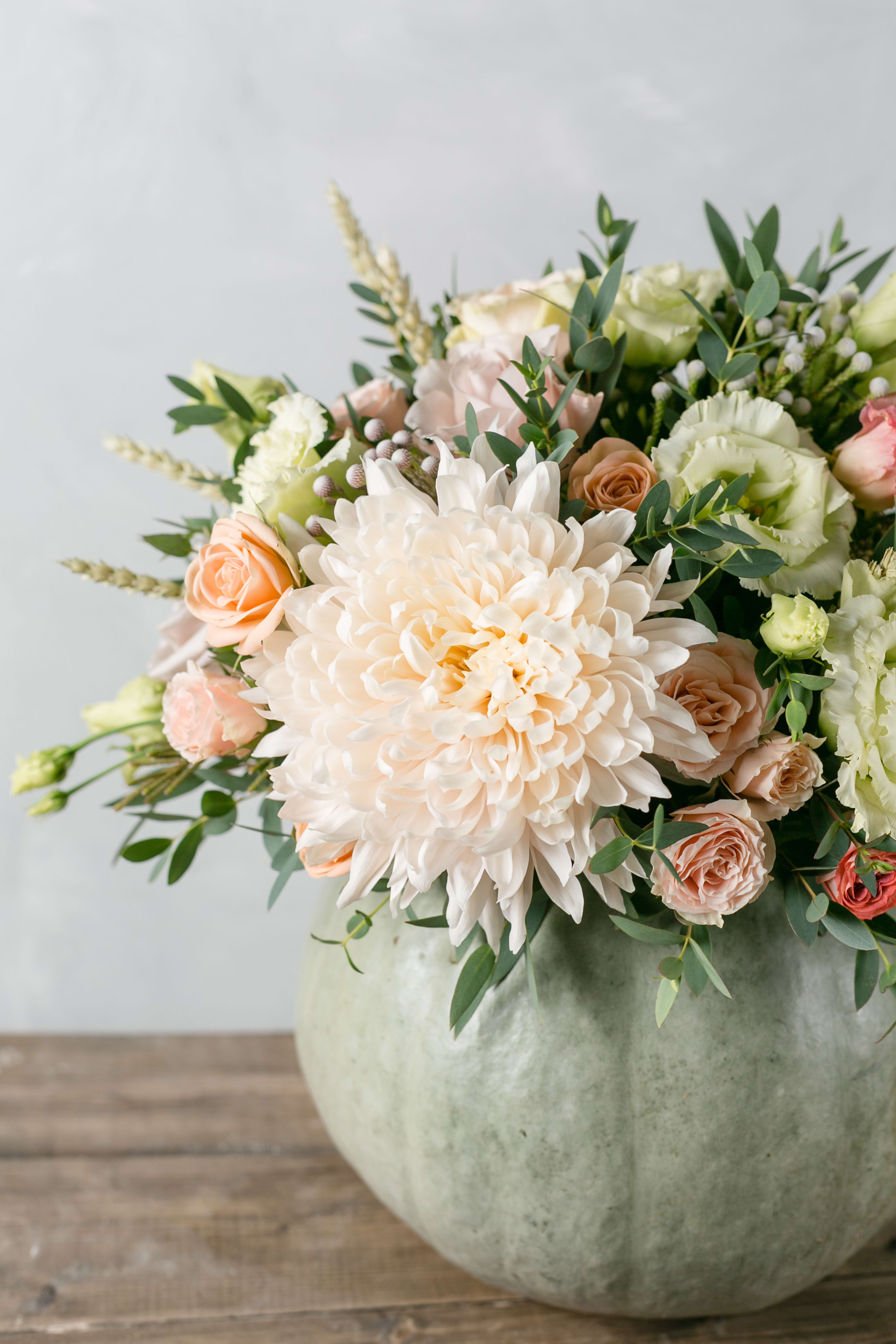 Bouquet of pale peach and white flowers in a round vase