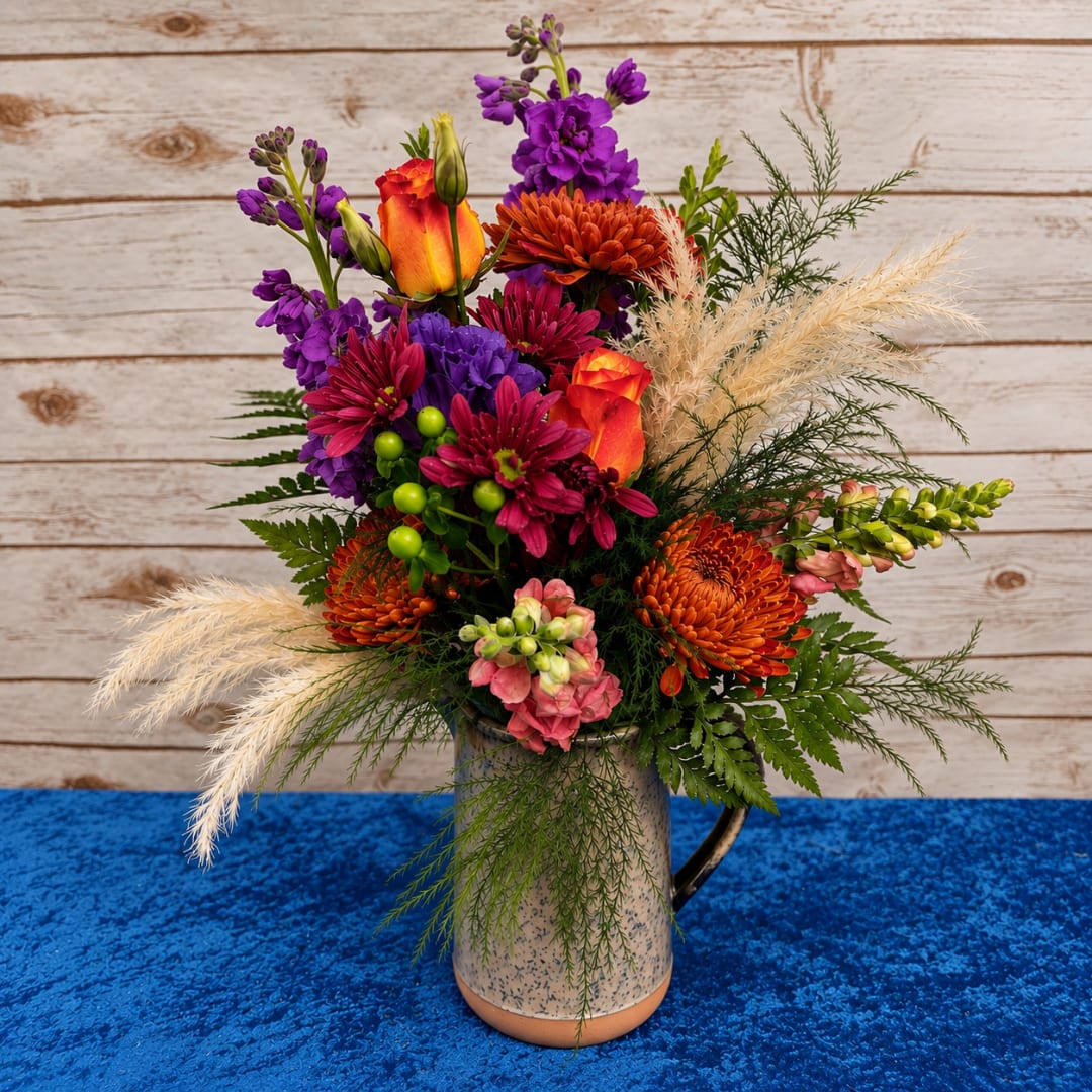 Colorful mixed bouquet in a speckled mug-style vase