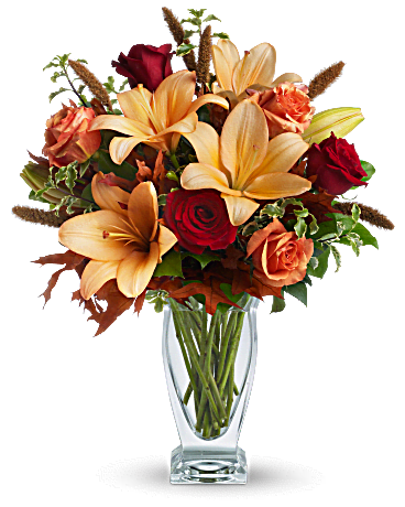 Bouquet of orange lilies and red roses in a clear glass vase