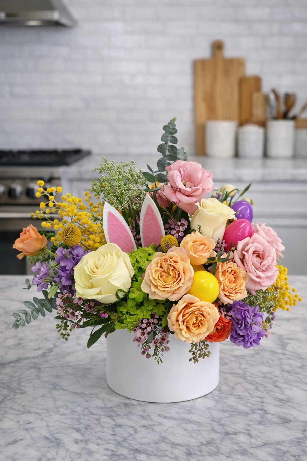 Pastel flower arrangement with roses and bunny ears pick in a white cylinder vase