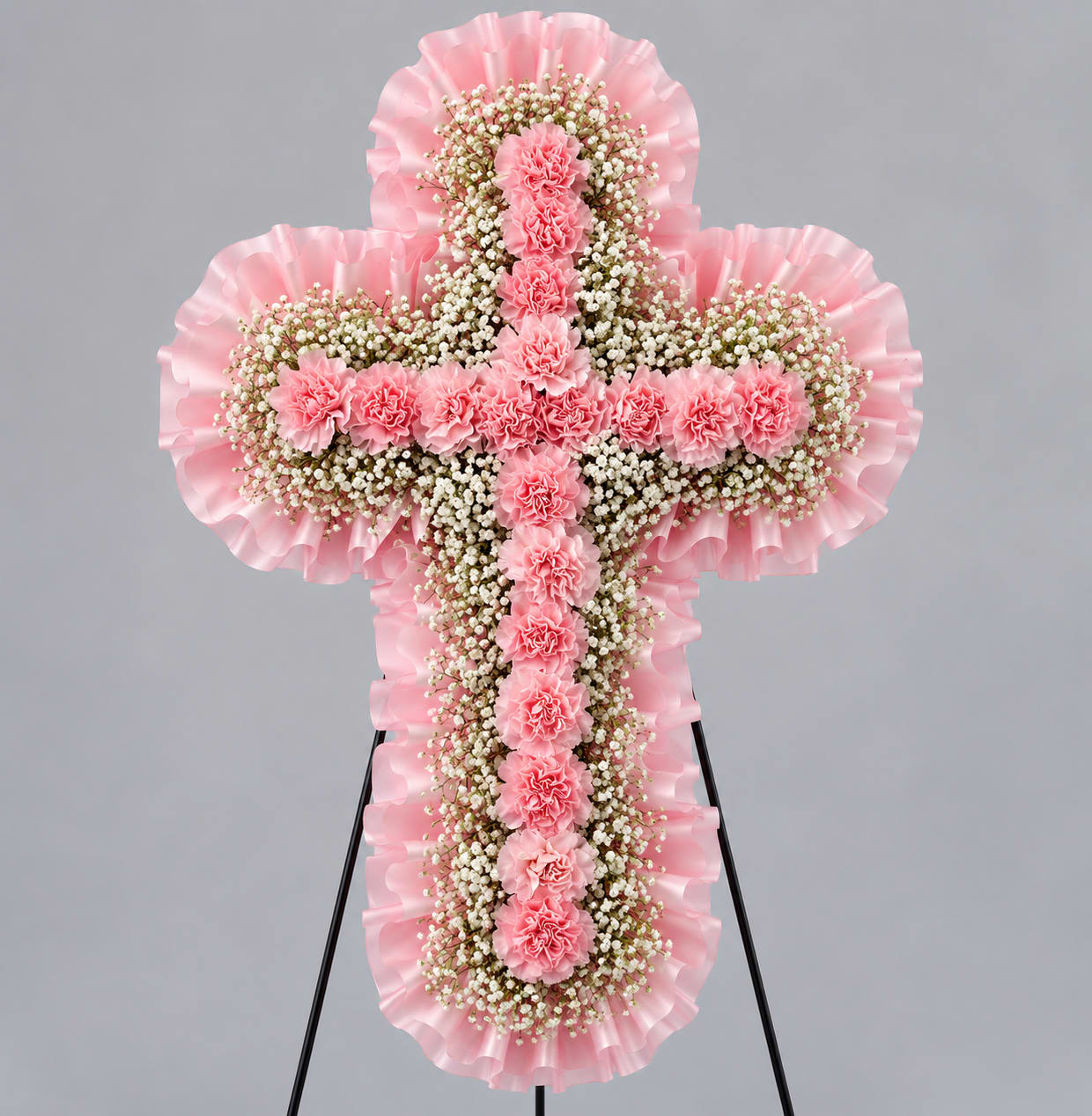 Pink floral cross-shaped standing arrangement on an easel