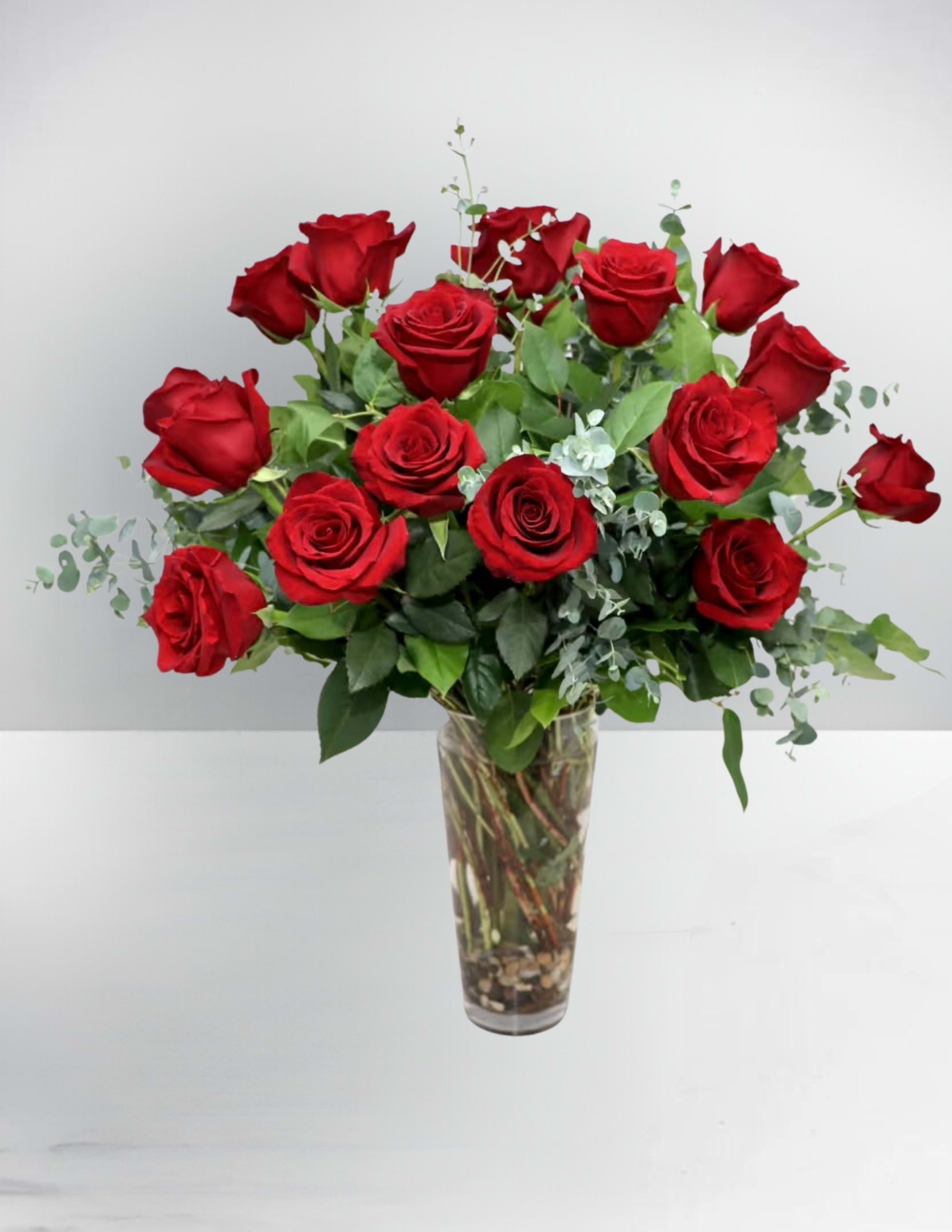 Red roses arranged in a clear glass vase