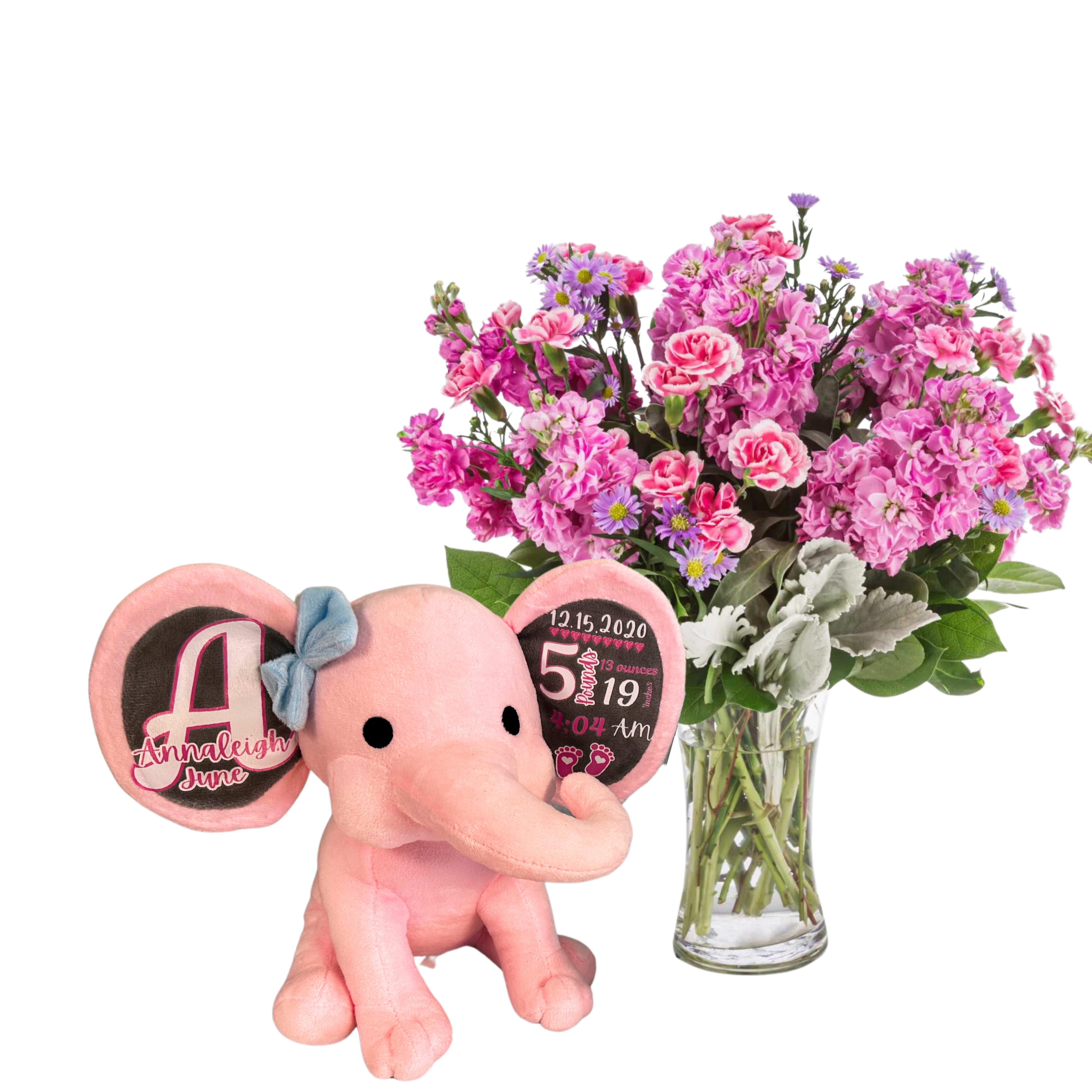 Pink plush elephant beside a vase of pink flowers