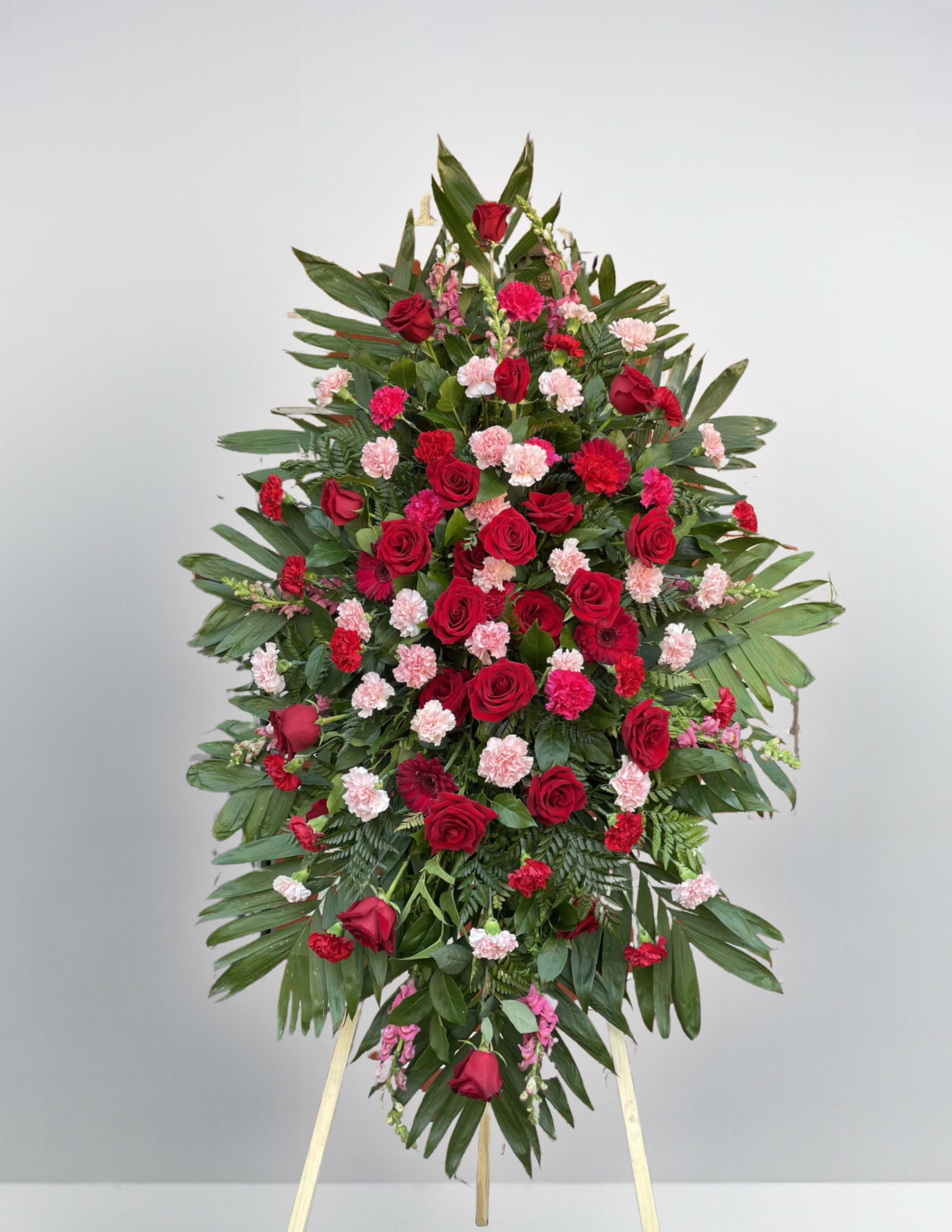 Large standing floral spray with red roses and pink carnations