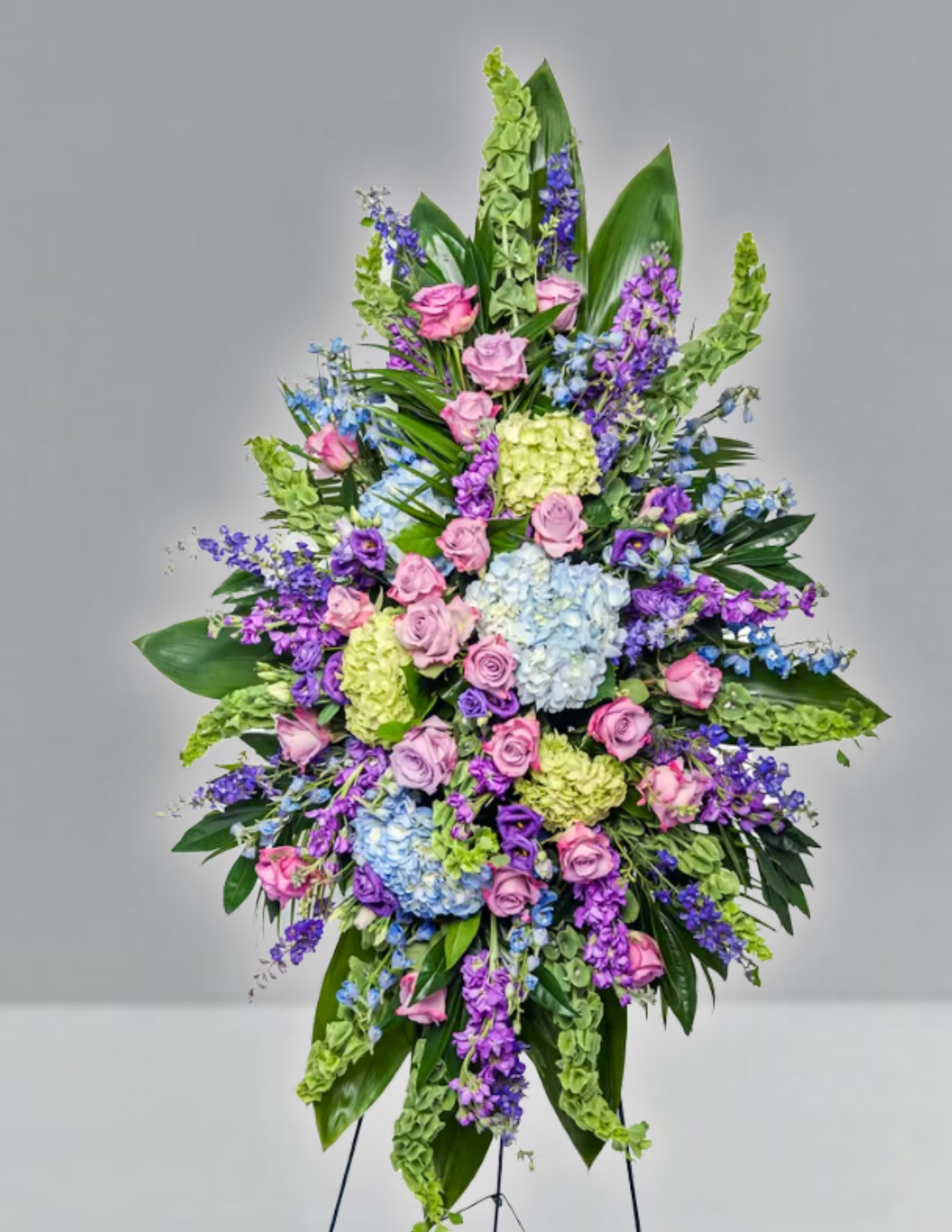 Large standing spray of pink, purple, blue, and green flowers