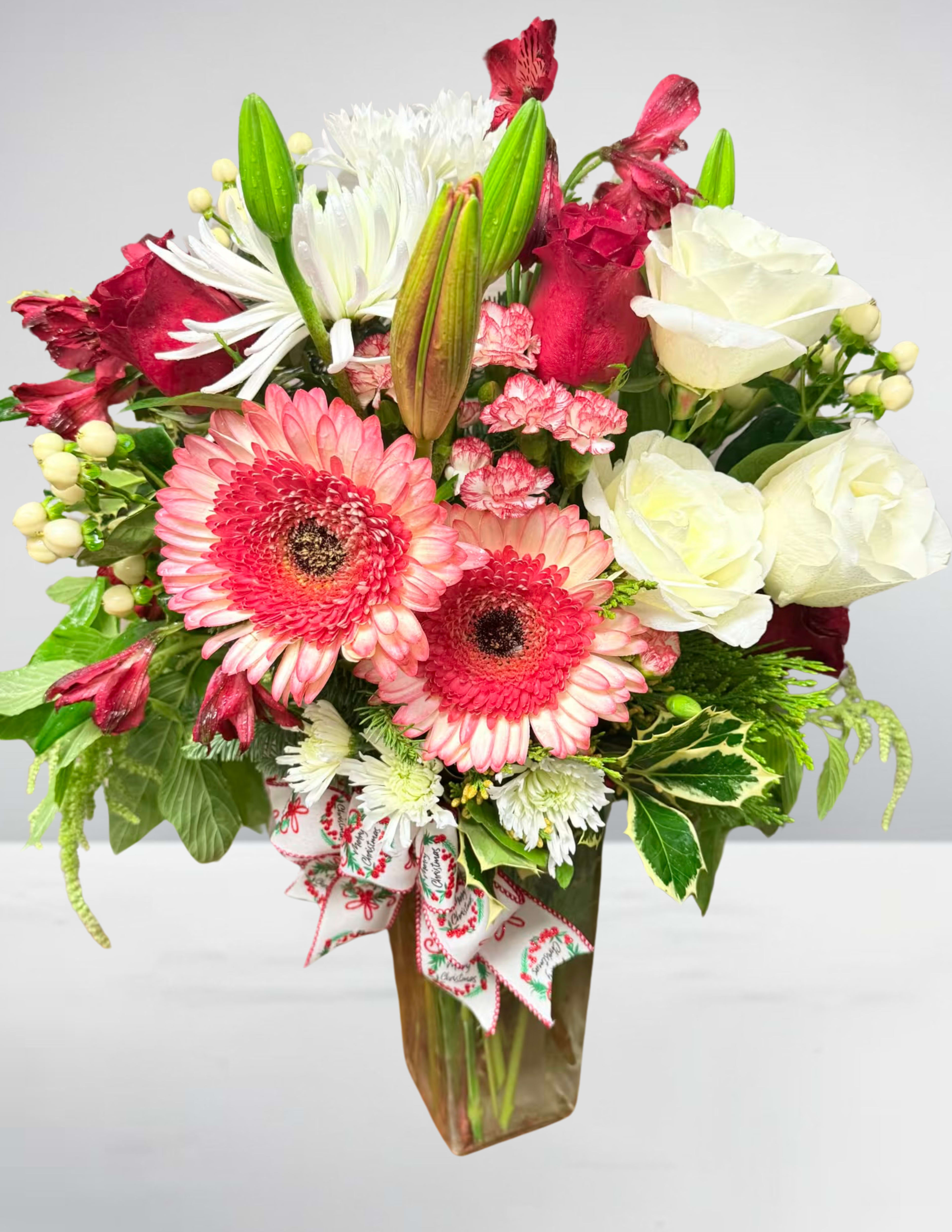 Mixed bouquet of pink gerbera daisies, white roses, and lilies in a vase