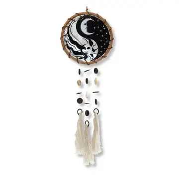 Round wall hanging with a black-and-white moon design and cream tassels