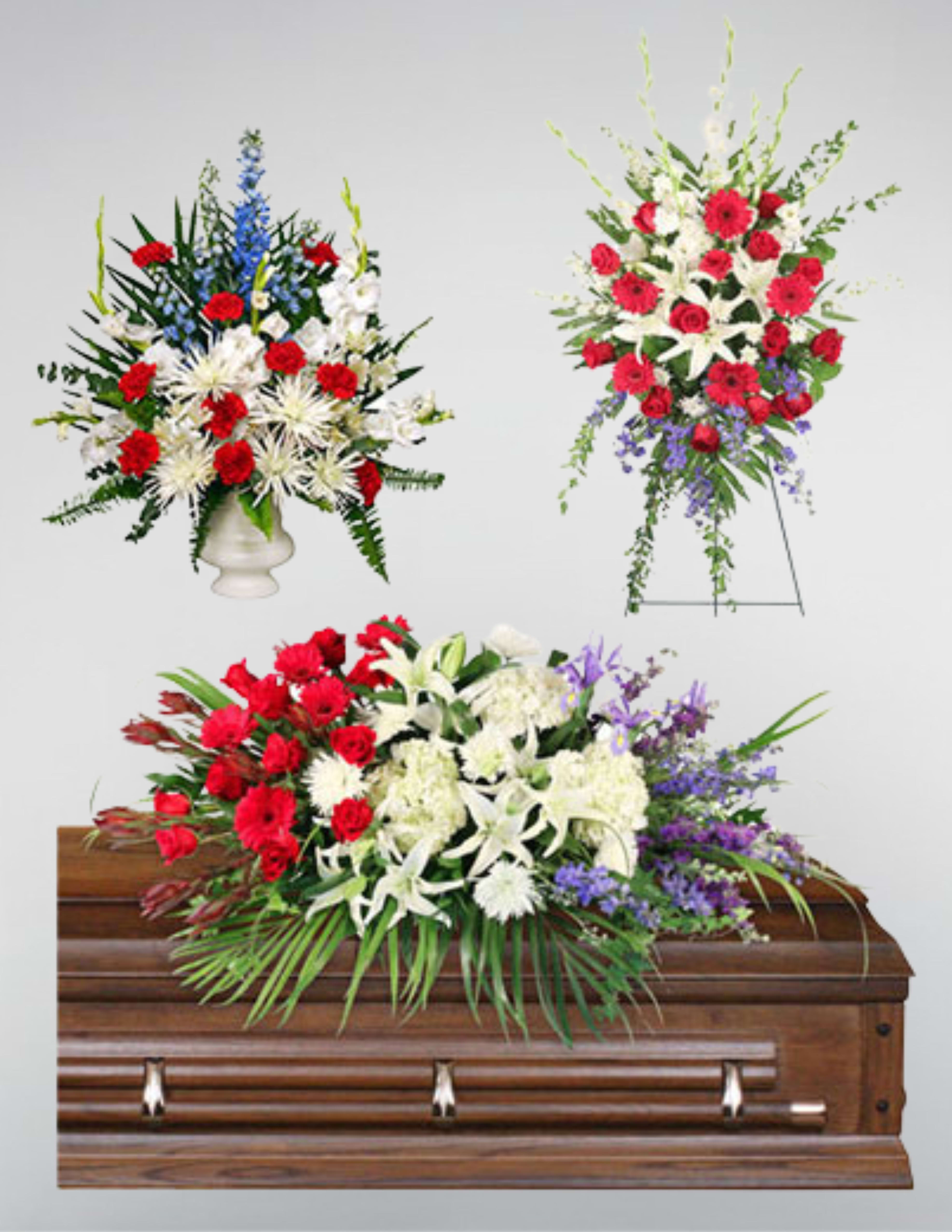 Three floral funeral sprays with red, white, and purple flowers around a casket