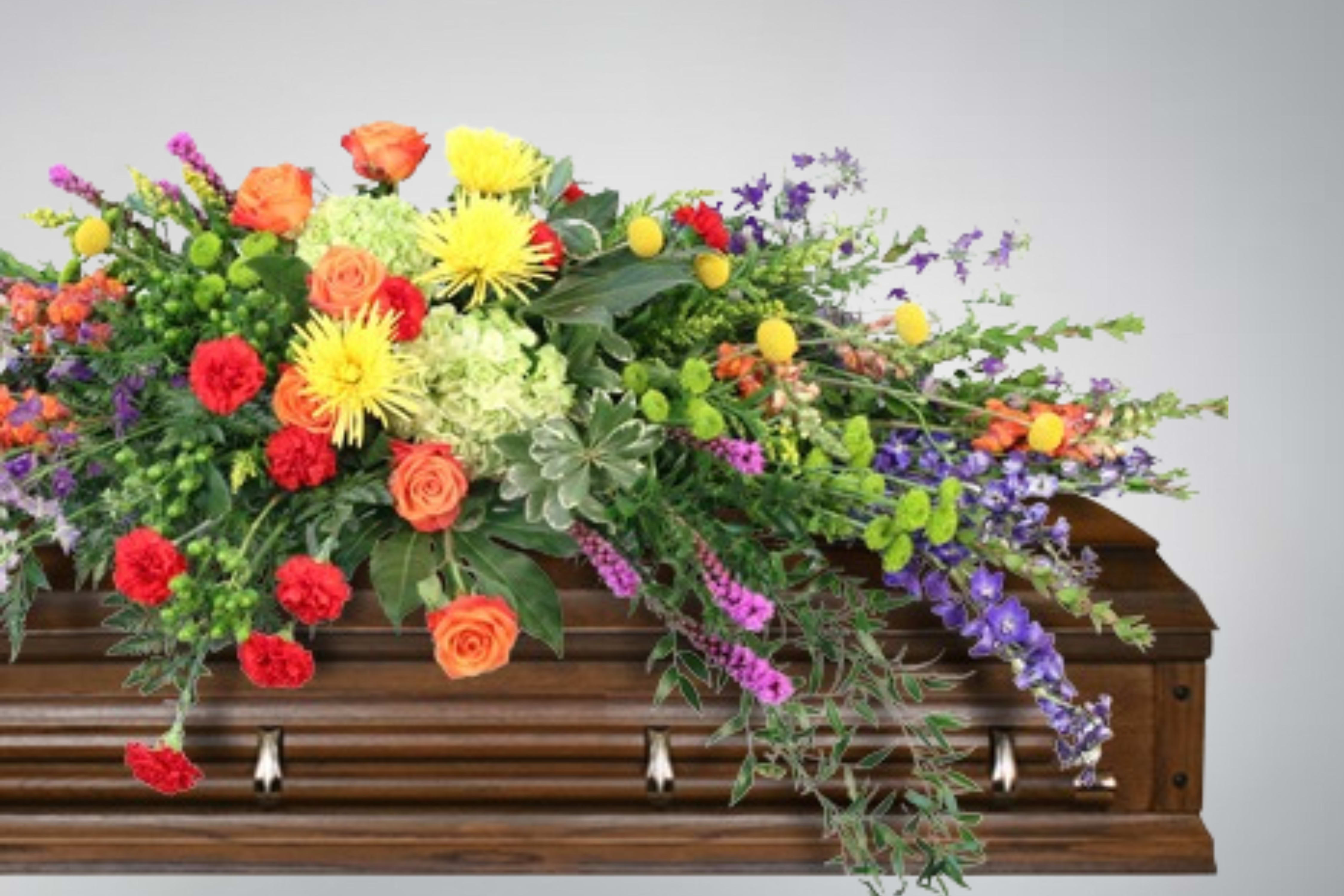 Colorful floral spray arranged on a wooden casket