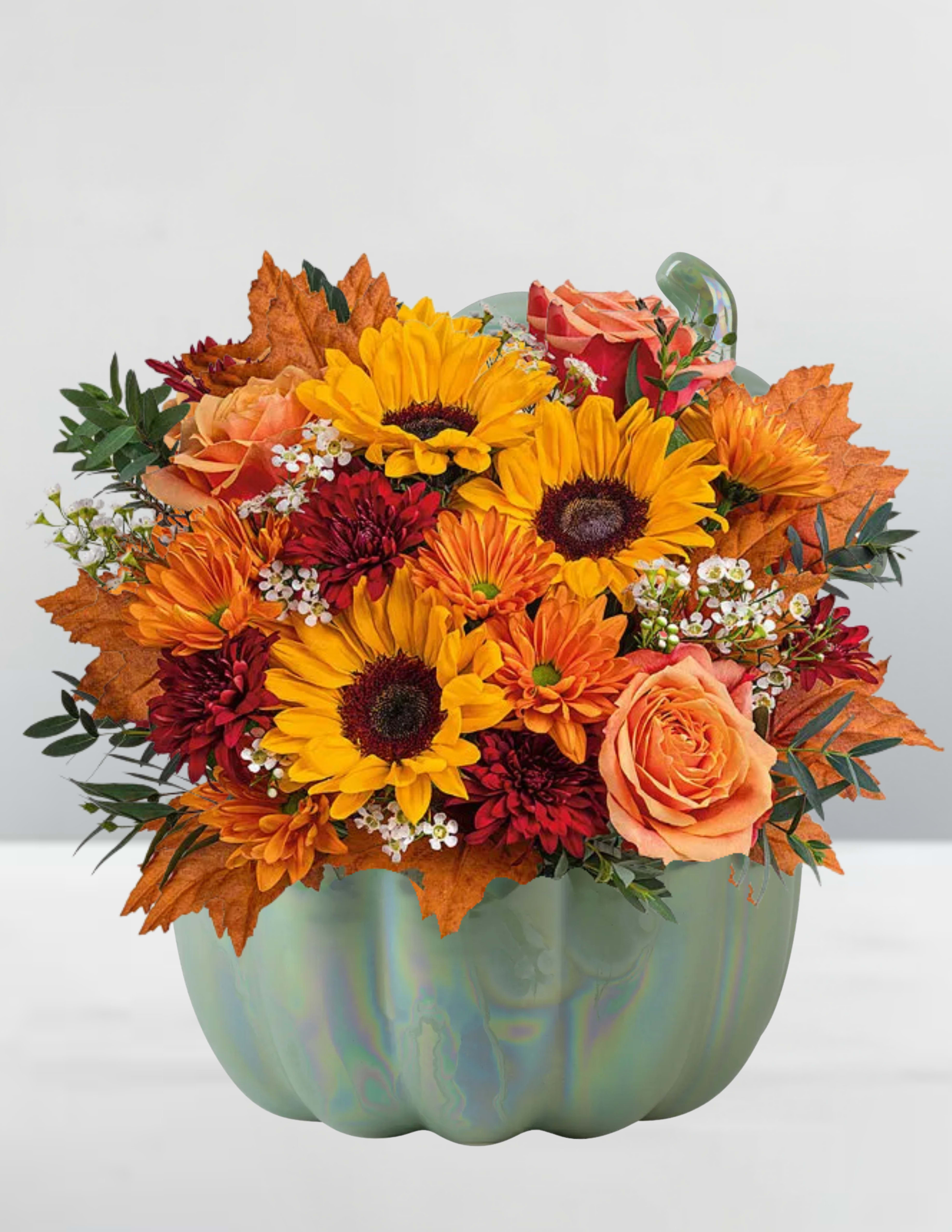 Autumn bouquet of sunflowers, roses, and mums in a pumpkin-shaped vase
