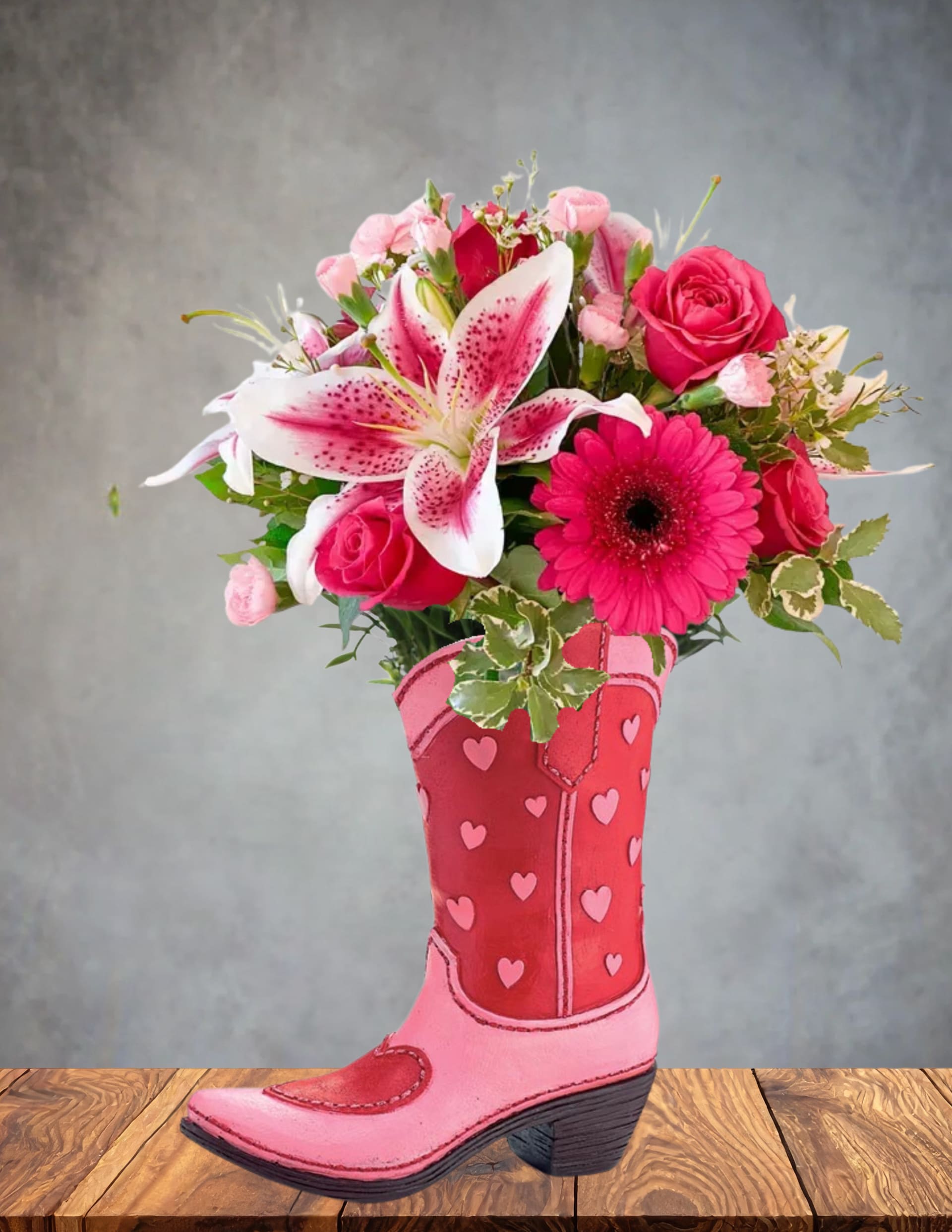 Pink roses and lilies arranged in a pink cowboy boot vase
