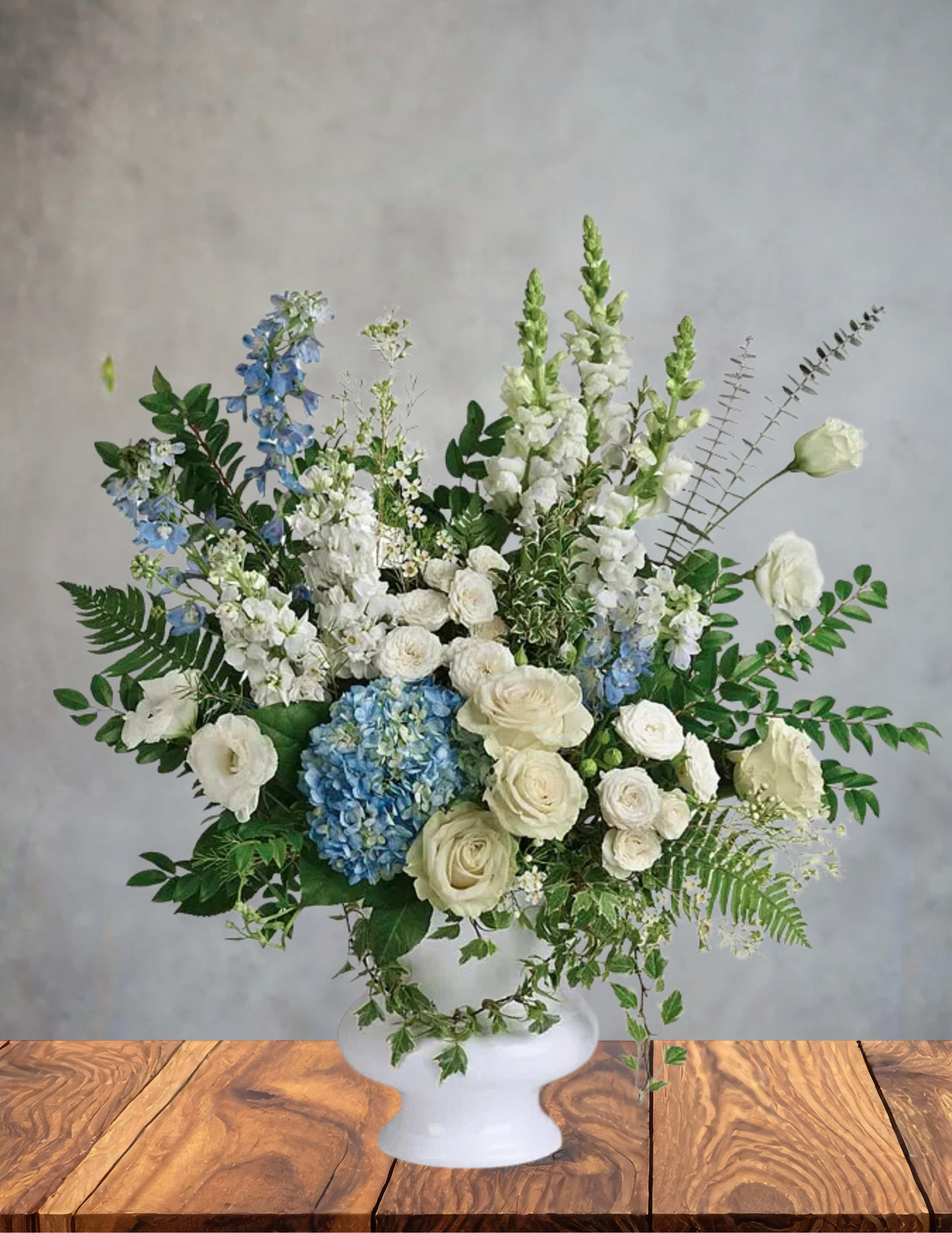White and blue floral arrangement in a white vase