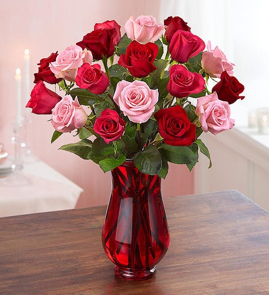 Bouquet of red and pink roses in a red glass vase