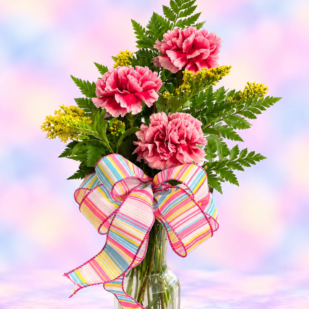 Pink carnations in a glass vase with a striped bow