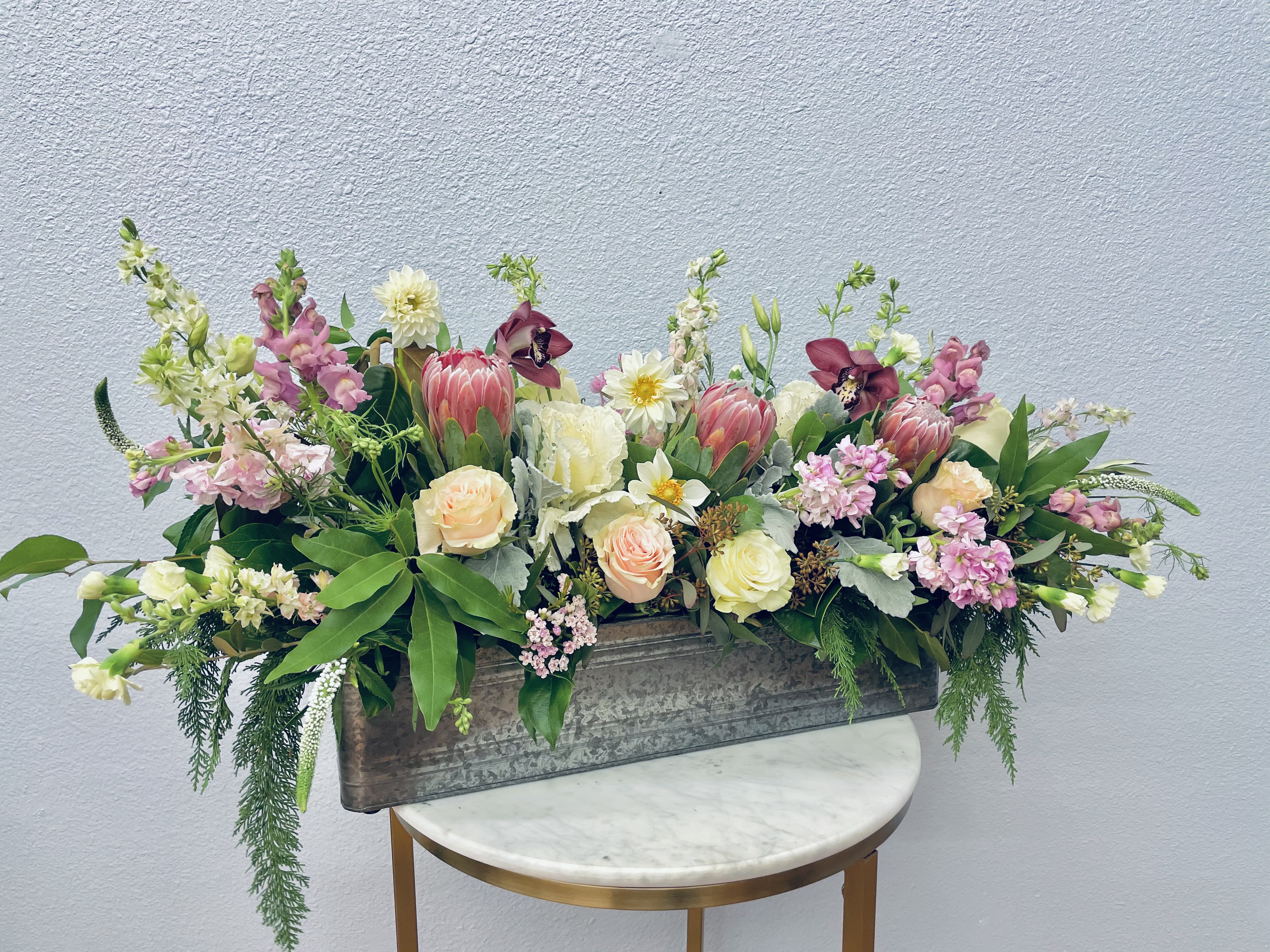Mixed floral arrangement in a rectangular metal planter