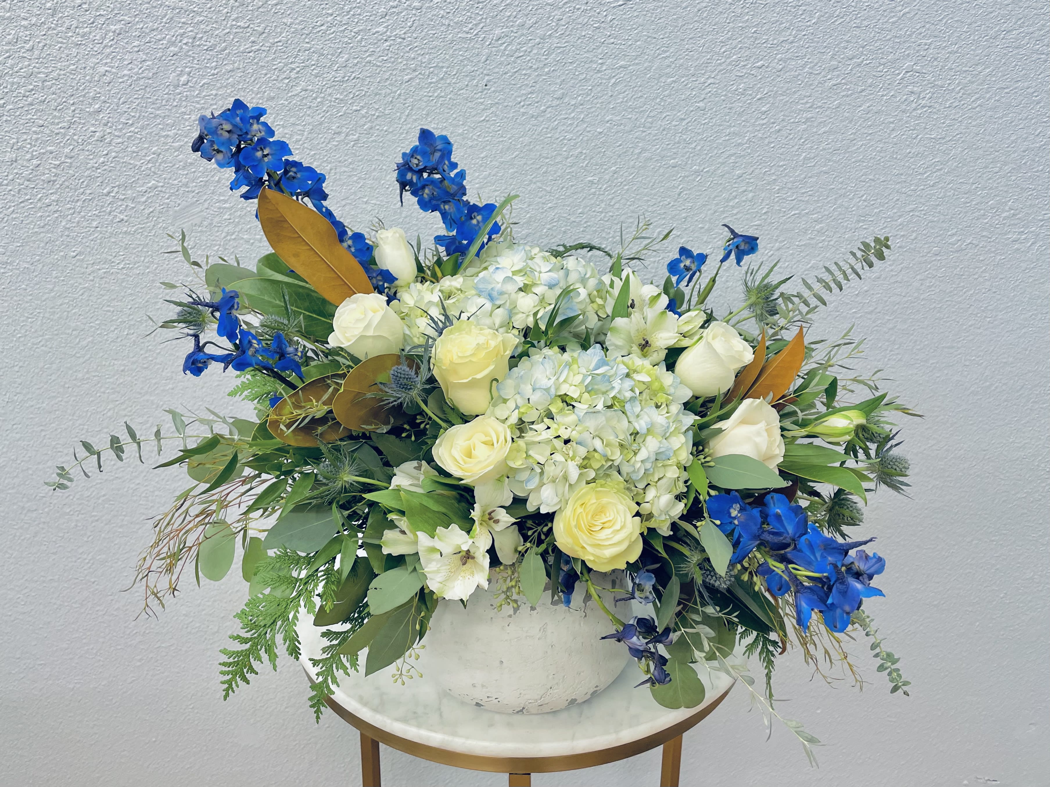 Blue and white floral arrangement in a white vase