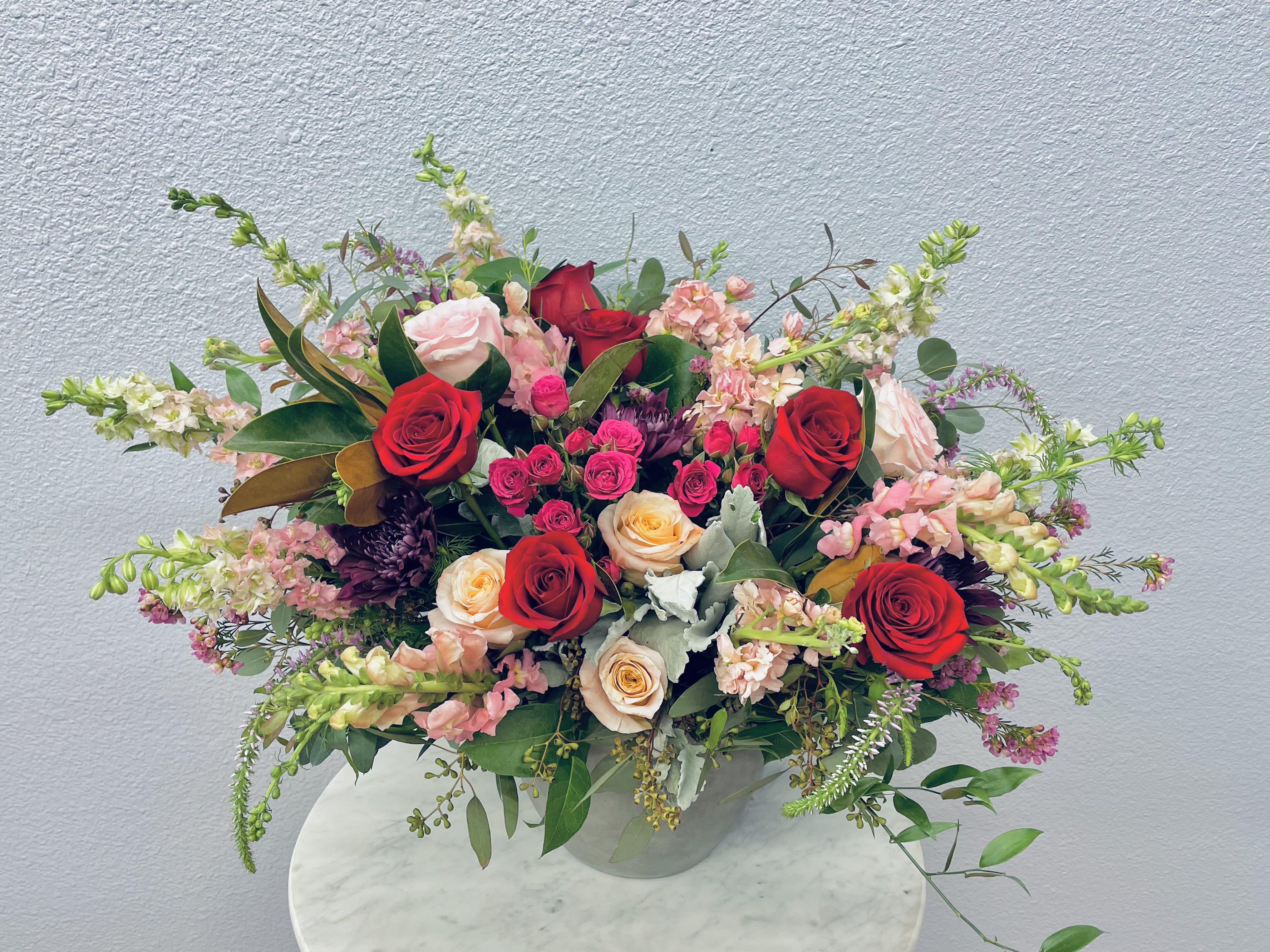Mixed bouquet of red and blush roses in a clear vase